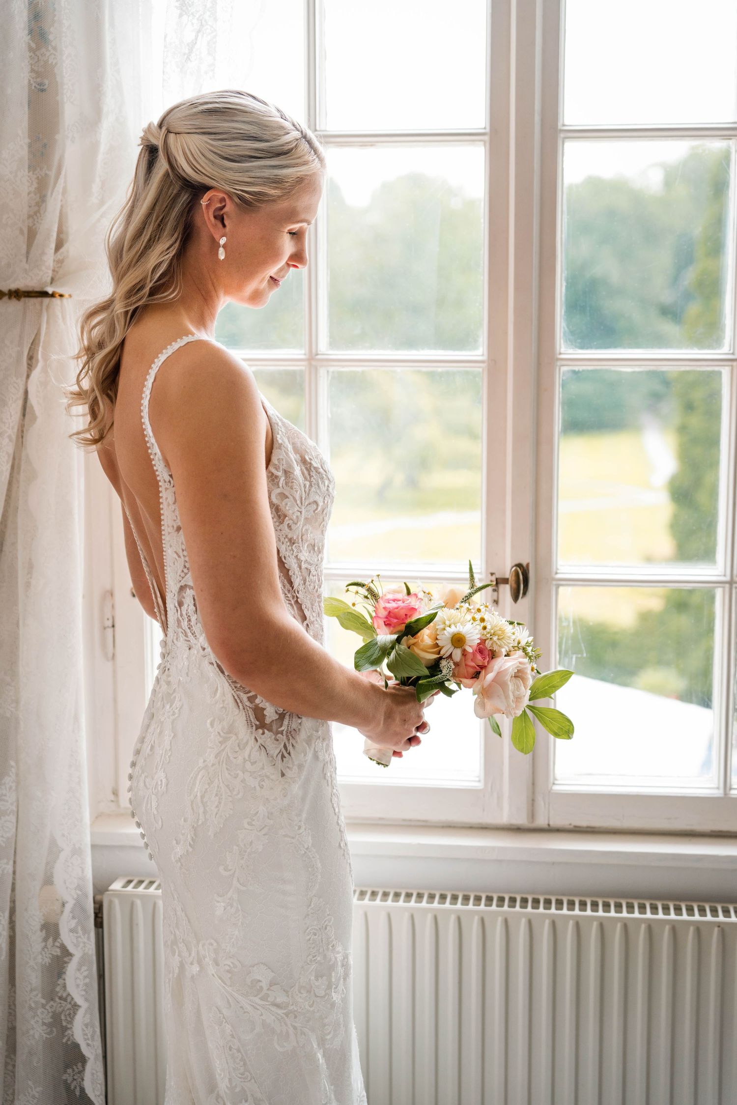 Wedding dress details captured in a series of window-lit photographs showing lace and floral bouquet.