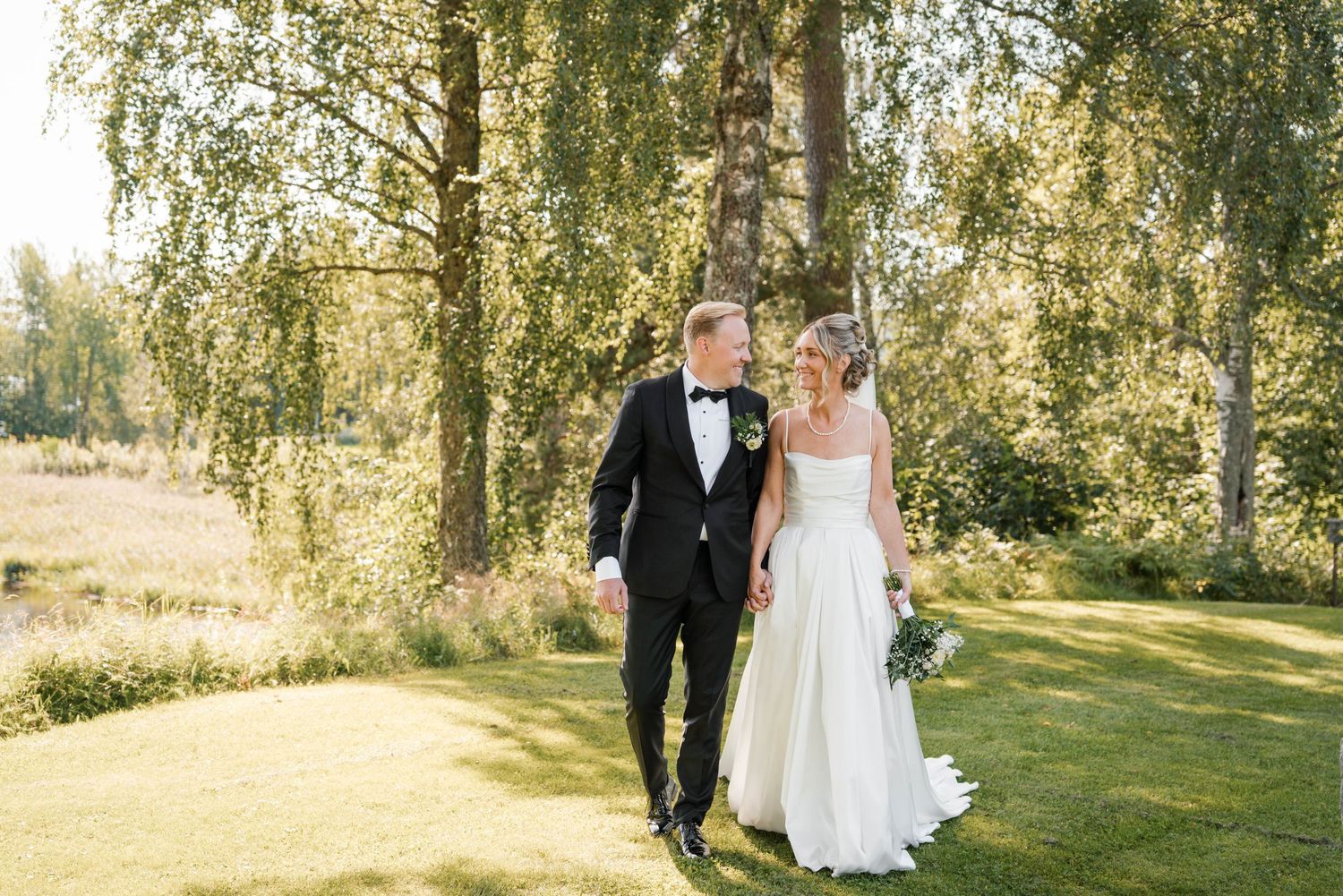 An outdoor wedding ceremony setting with birch trees and natural sunlight filtering through.