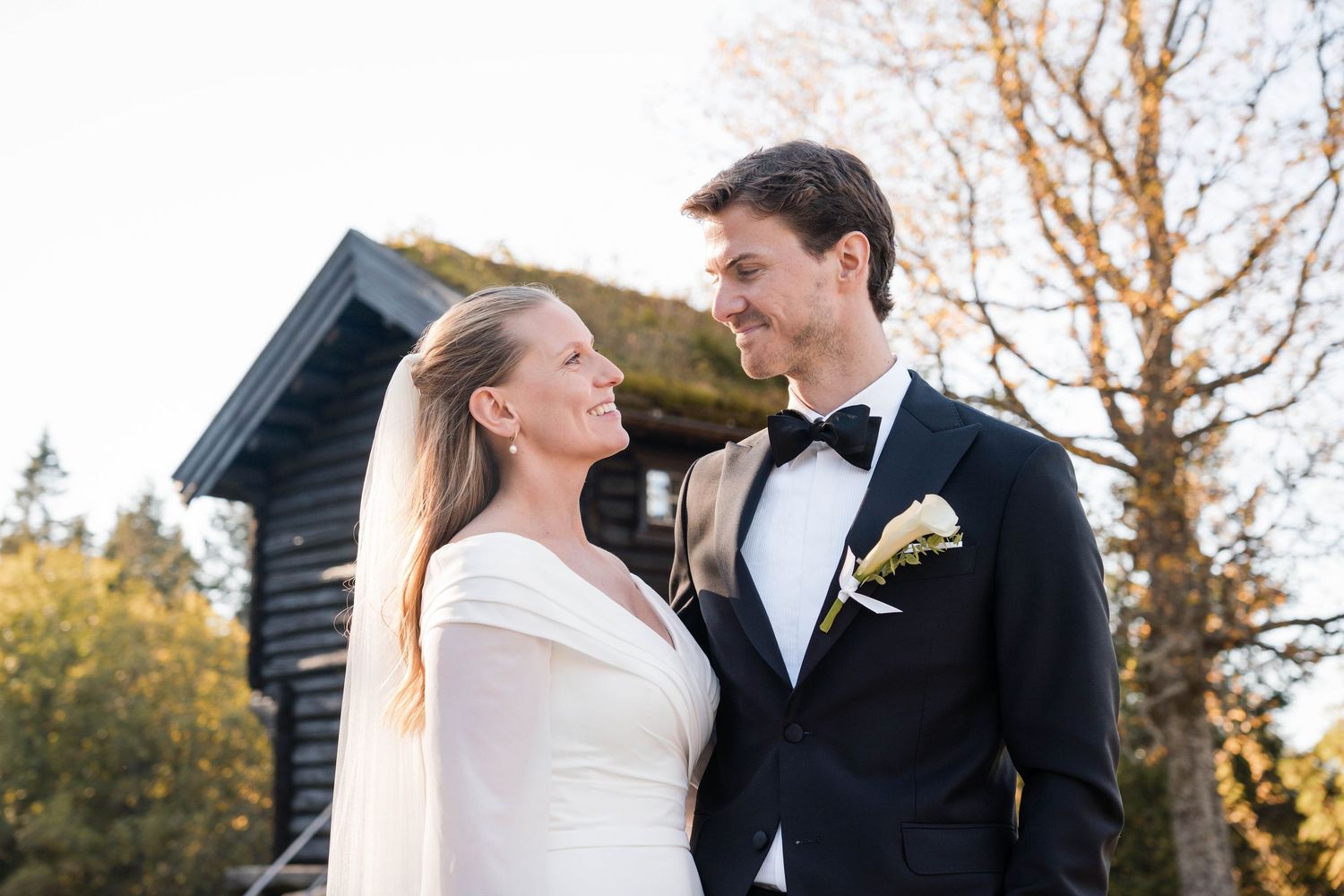 Elegant wedding couple shares romantic moment in outdoor garden setting.