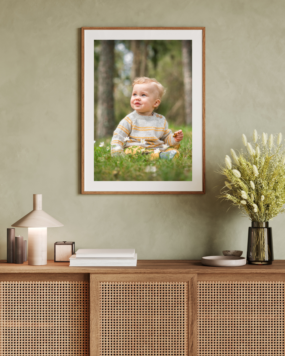 Modern interior design with wooden cane cabinet, framed photos, and white floral arrangements on display.