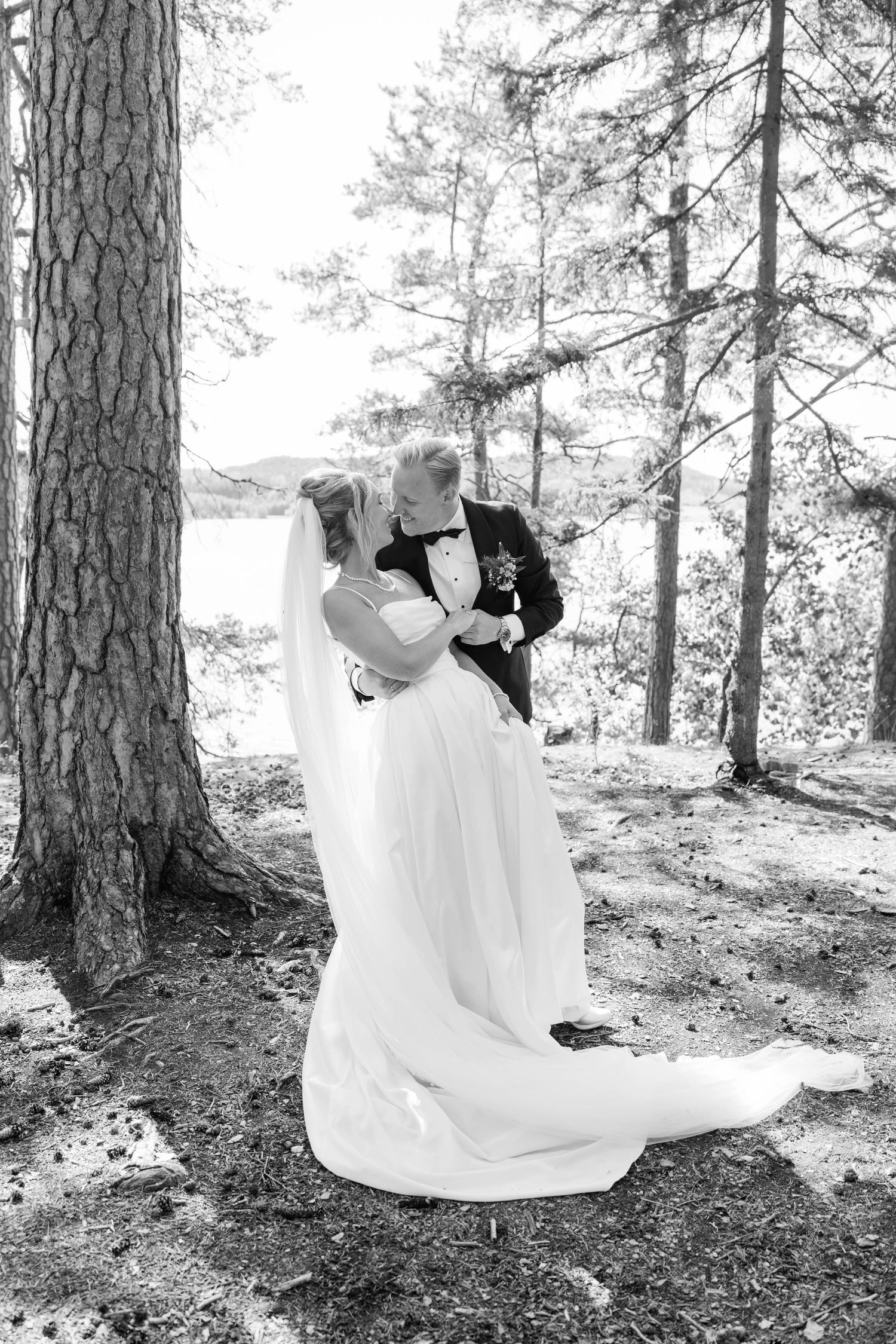 Black and white wedding photos captured in a scenic pine forest setting.