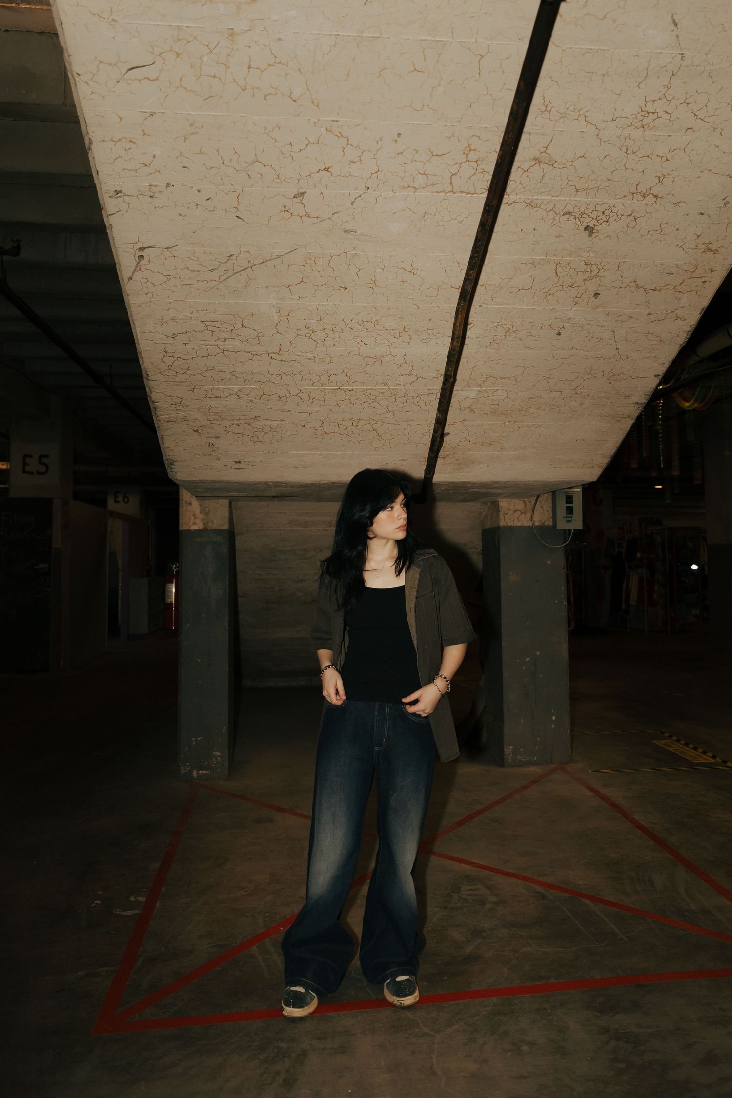 Minimalist photo series showing legs and feet against a concrete floor with red lines.
