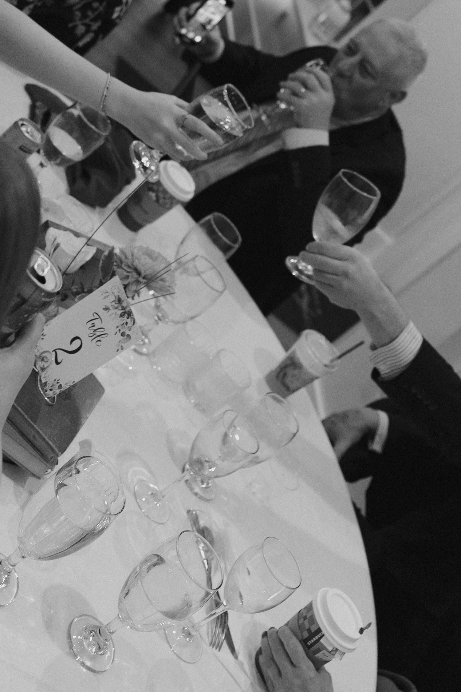 People gathered around a table with wine glasses and place settings for a formal dining experience.
