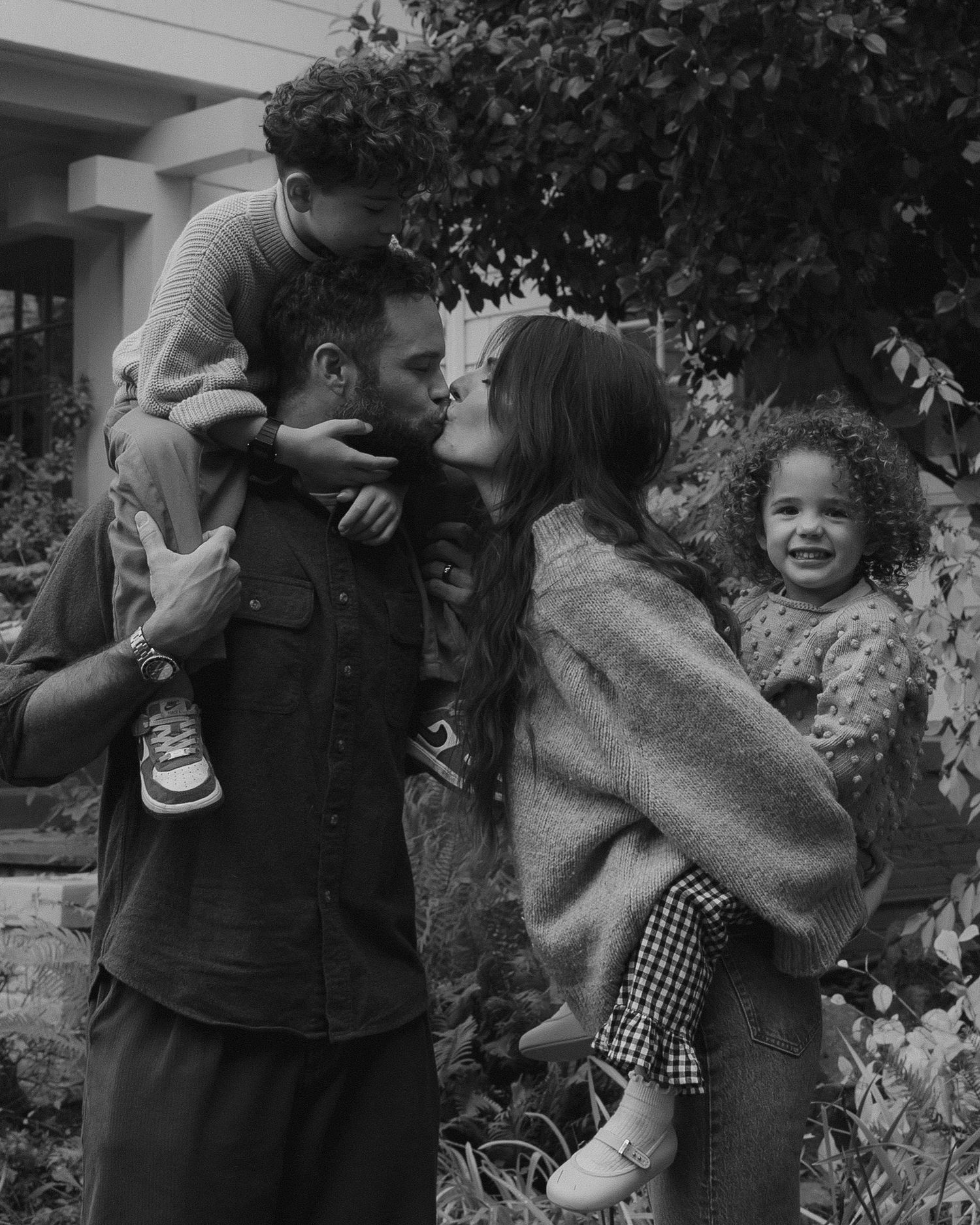 Black and white sequence of playful moments between two people embracing outdoors.