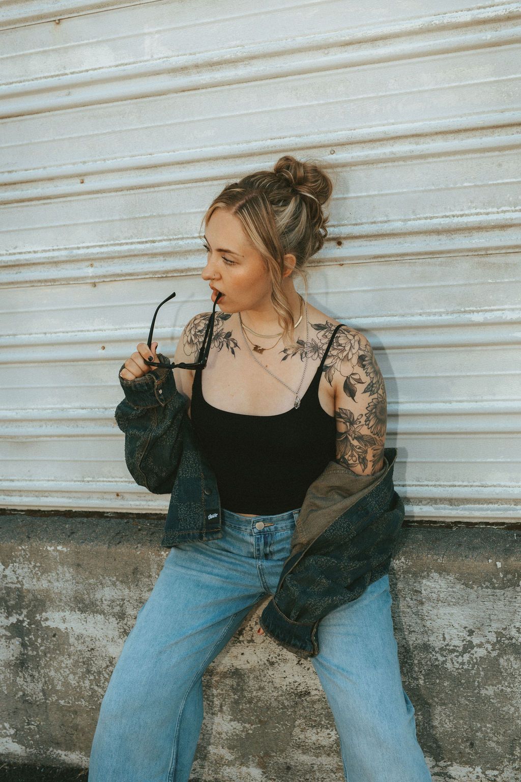 Fashion sequence showing denim and black outfit against white industrial wall.
