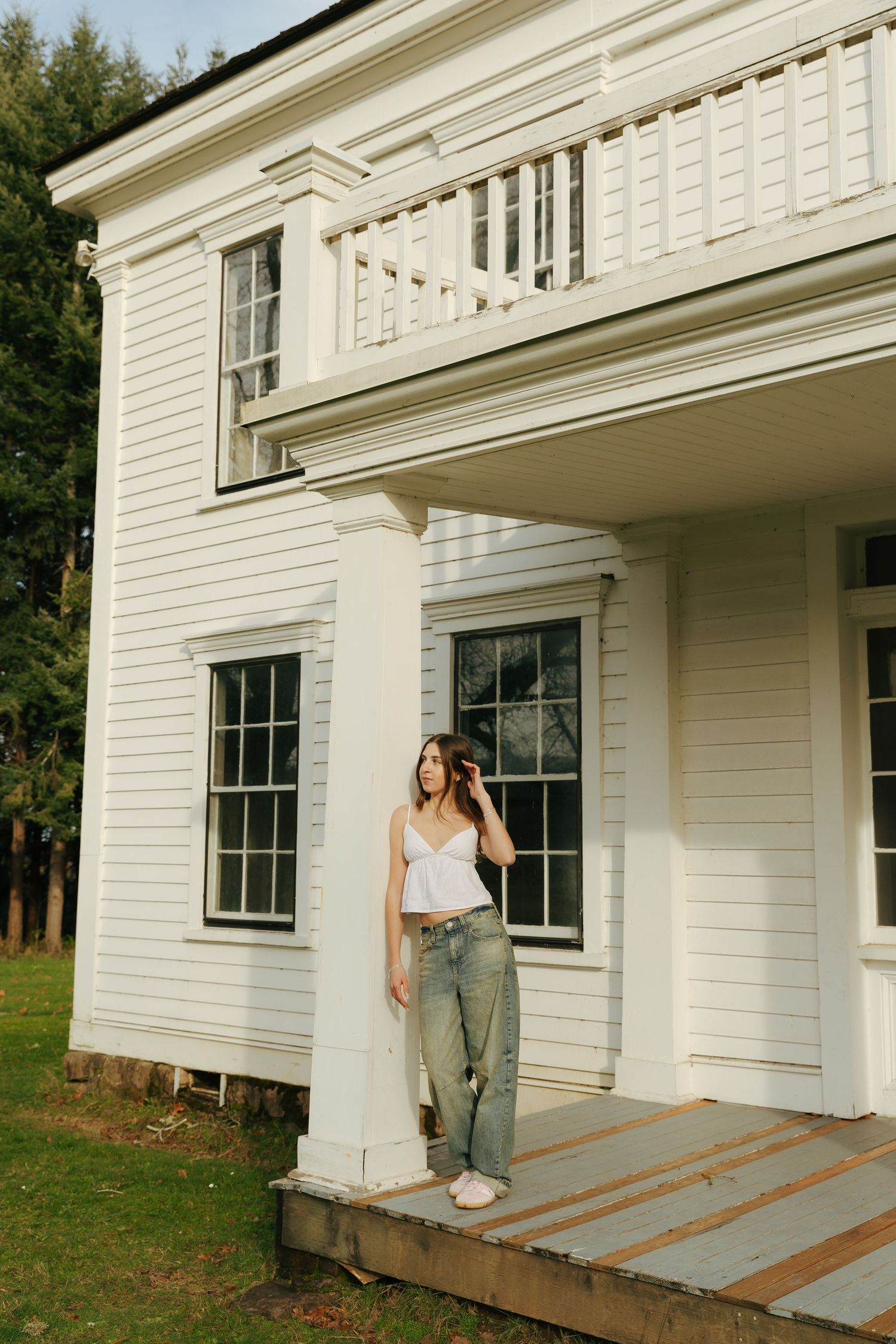 A white farmhouse exterior with classic architectural details and wooden steps.