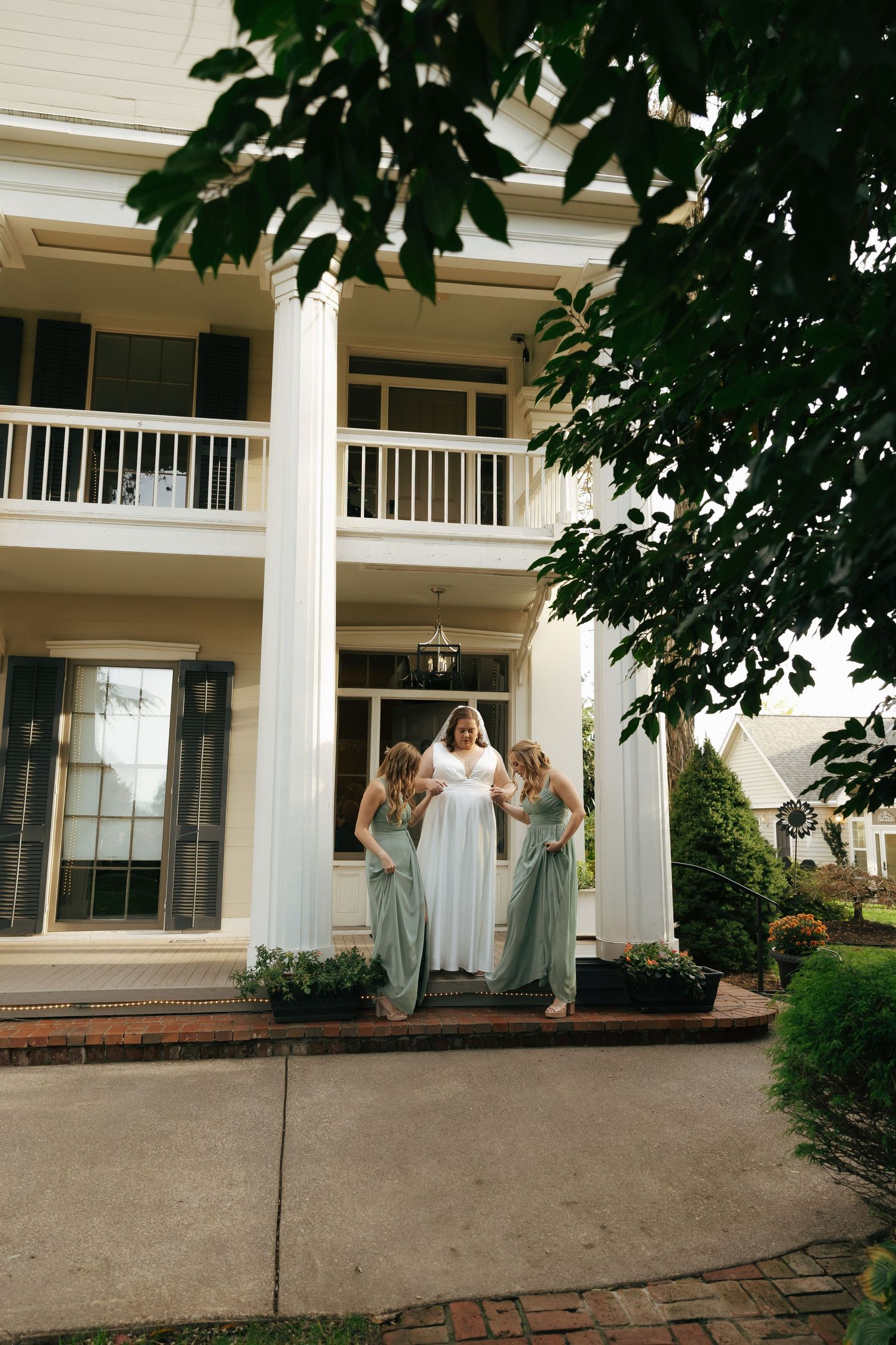 A series of photos showing the exterior of a white columned mansion with green foliage and brick walkway.