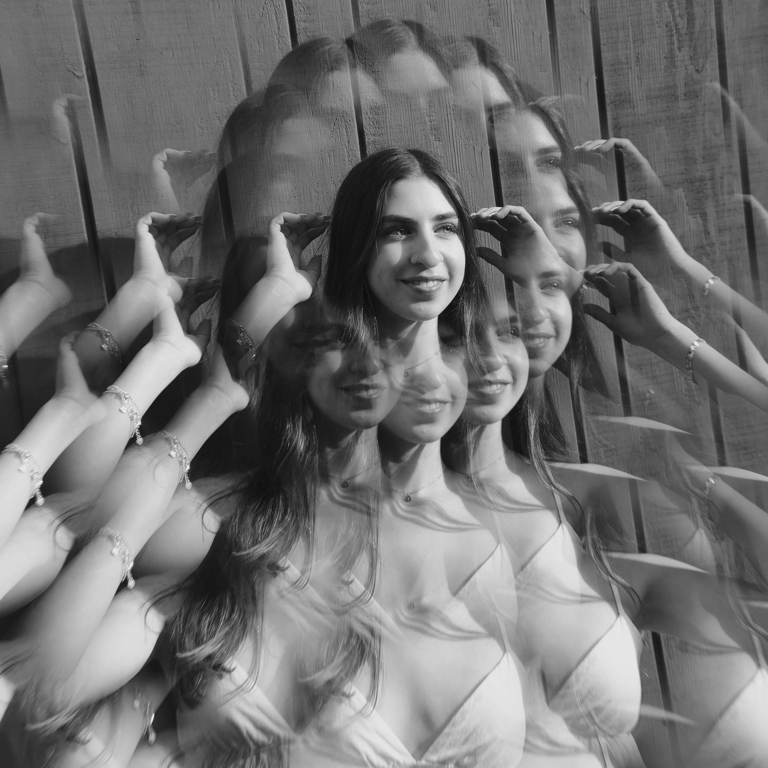 Black and white photo series showing joyful expressions and raised hands against a wall.