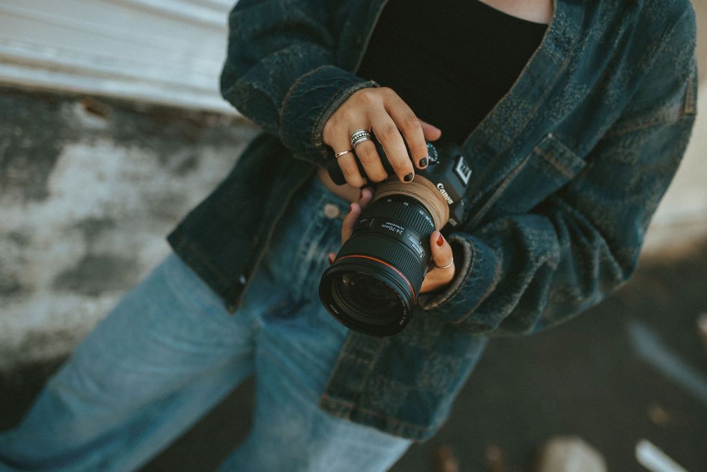 Close-up detail shots of denim jacket and accessories against industrial background.