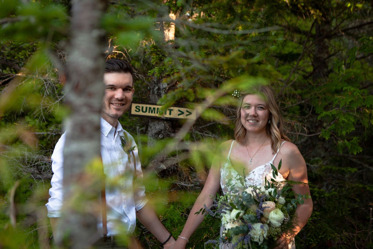 Newlyweds celebrate with sparklers during outdoor mountain wedding ceremony.