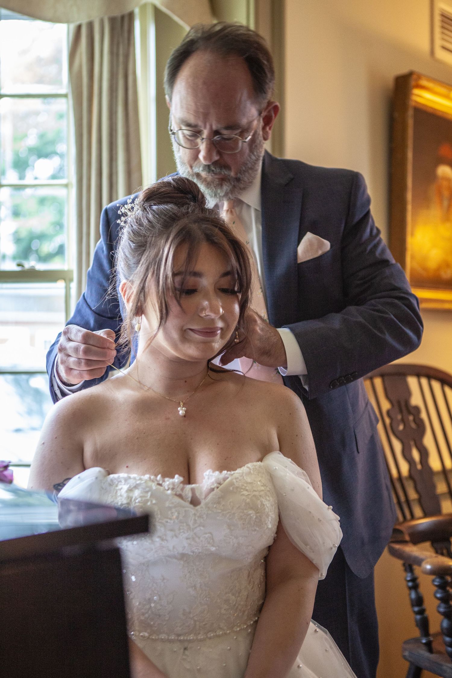 An elegant bridal preparation moment captured in a warmly lit room with classic decor.