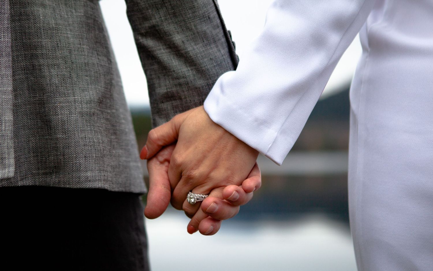 Close-up detail shots of couple holding hands in formal attire.