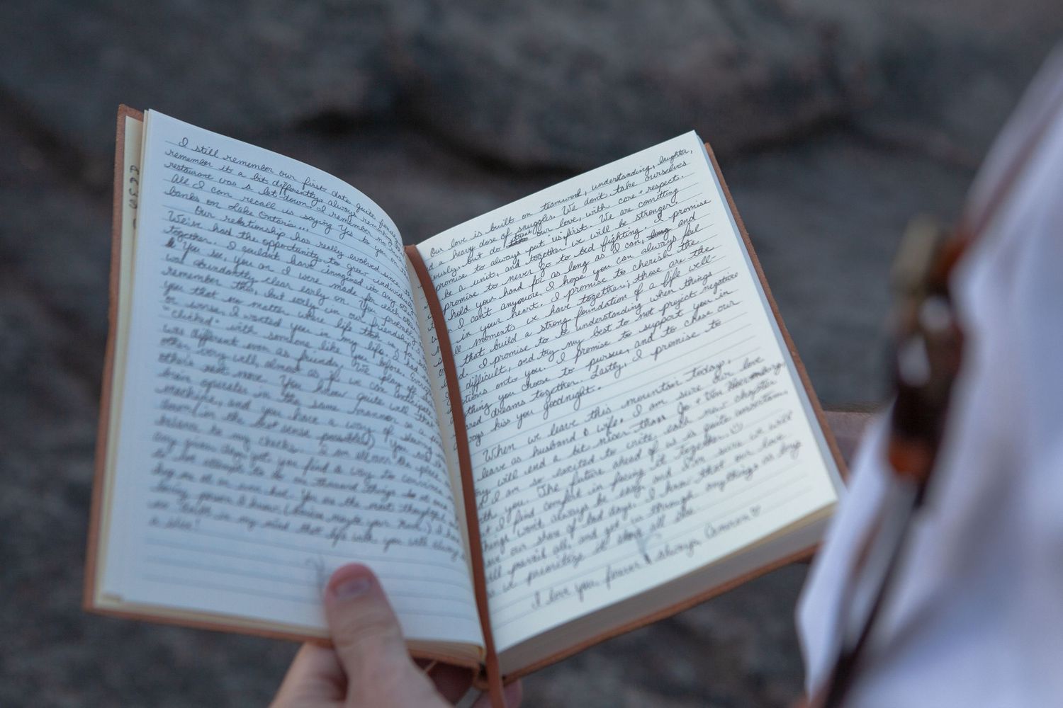 Handwritten wedding vows displayed in open journal against dark background.