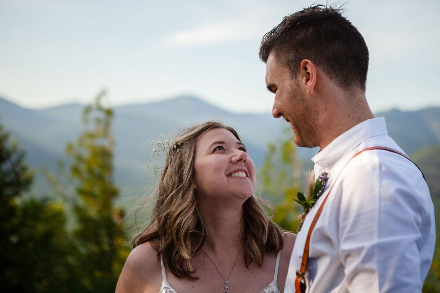 Wedding couple shares romantic moment against scenic mountain landscape at golden hour.