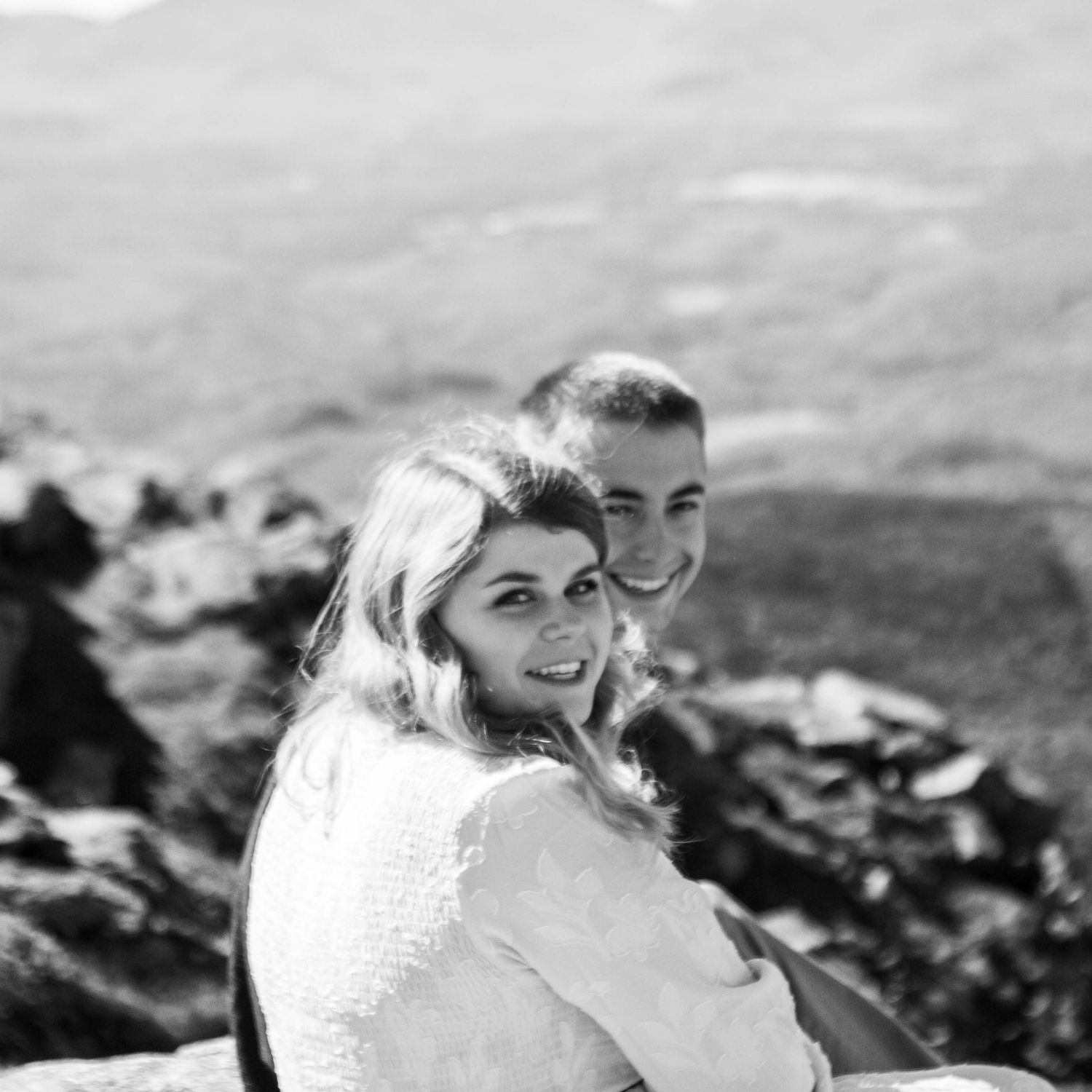 A romantic black and white portrait of a couple sharing an intimate moment outdoors.