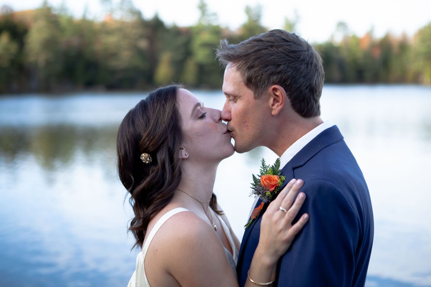 Romantic lakeside wedding portraits with mountains and water in background.