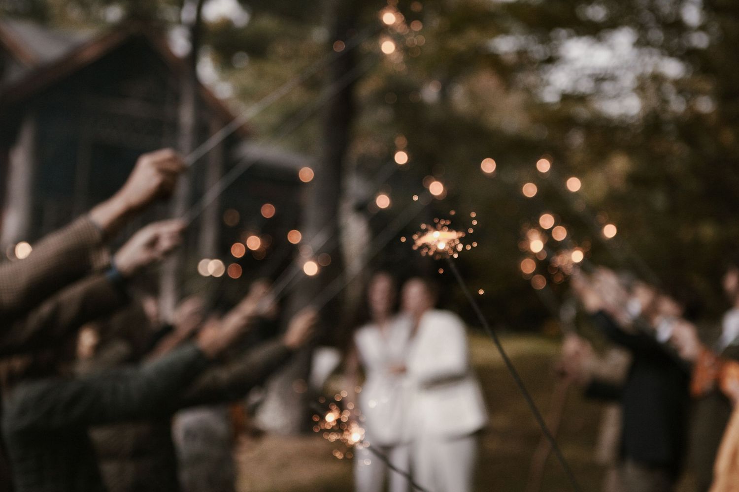 Sparklers create trails of light during an outdoor evening celebration.