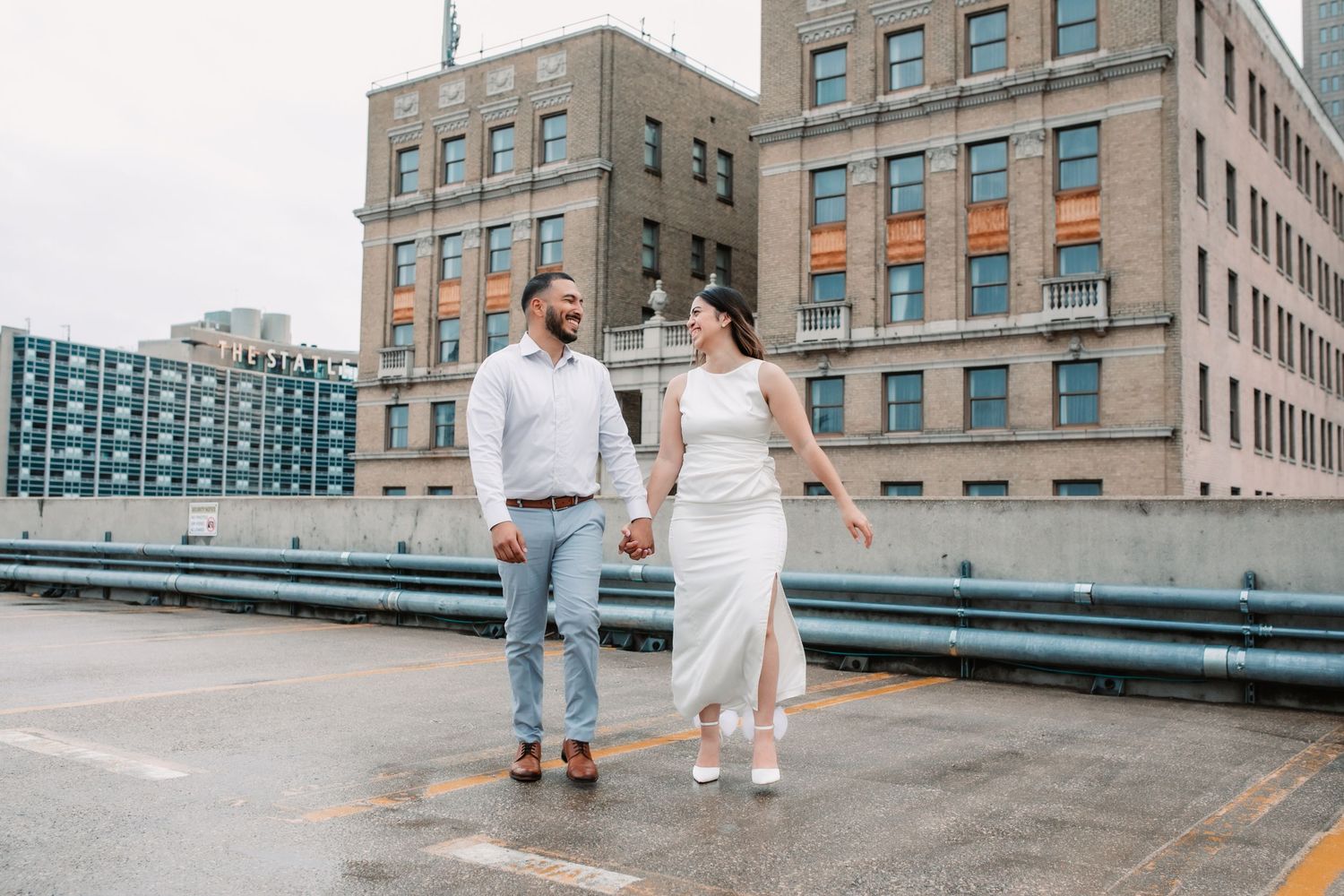 Urban photoshoot on downtown street with historic brick buildings and modern architecture.