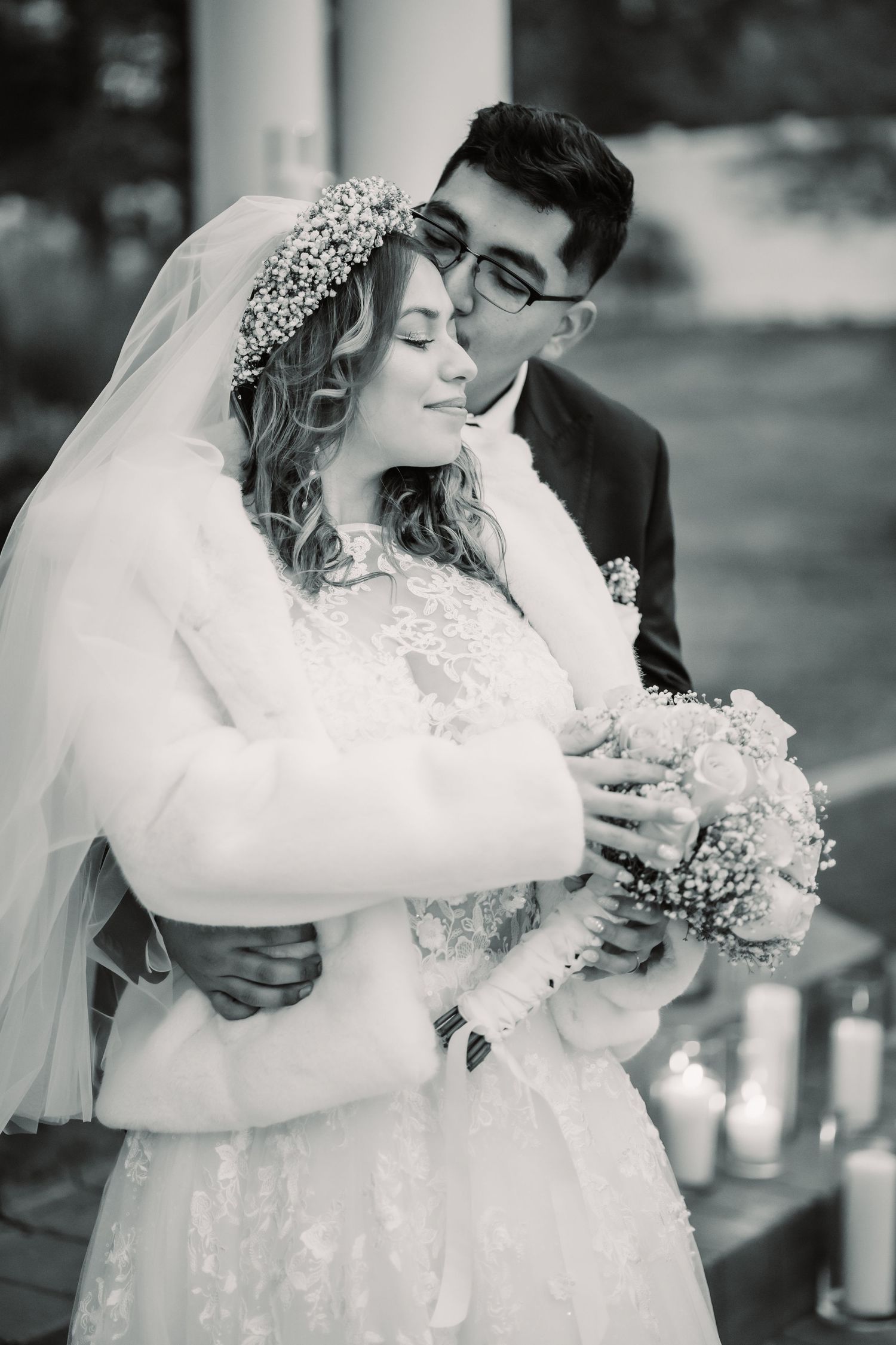 Romantic black and white wedding photos showing tender moments between newlyweds with bride in lace dress and flowing veil.