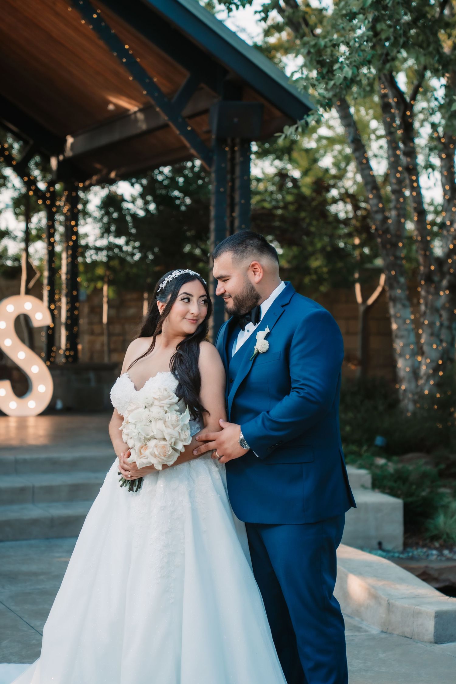 Romantic wedding portraits taken in a garden setting with natural greenery.