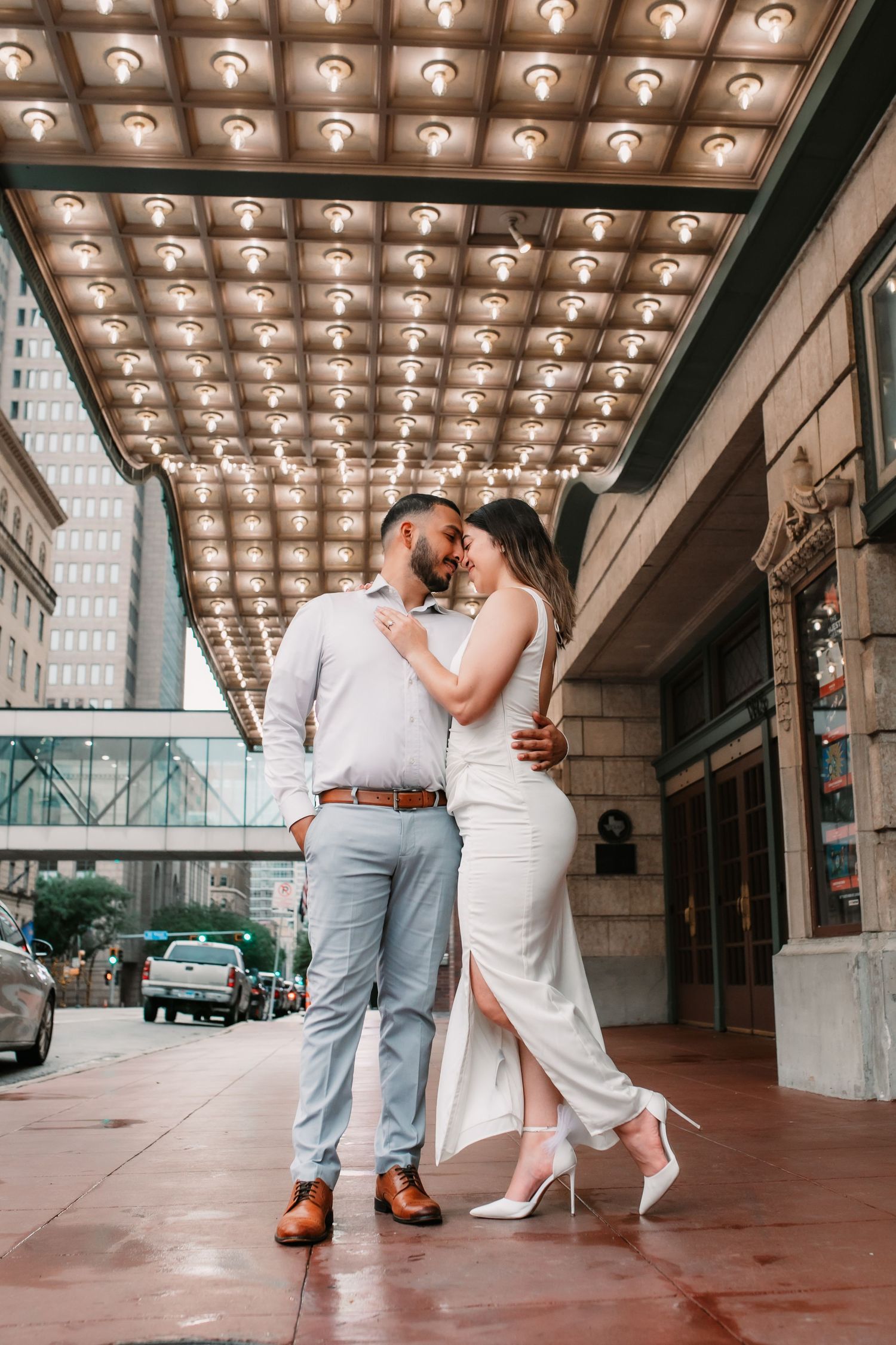 Vintage theater marquee lights create dramatic ceiling for romantic urban photography.