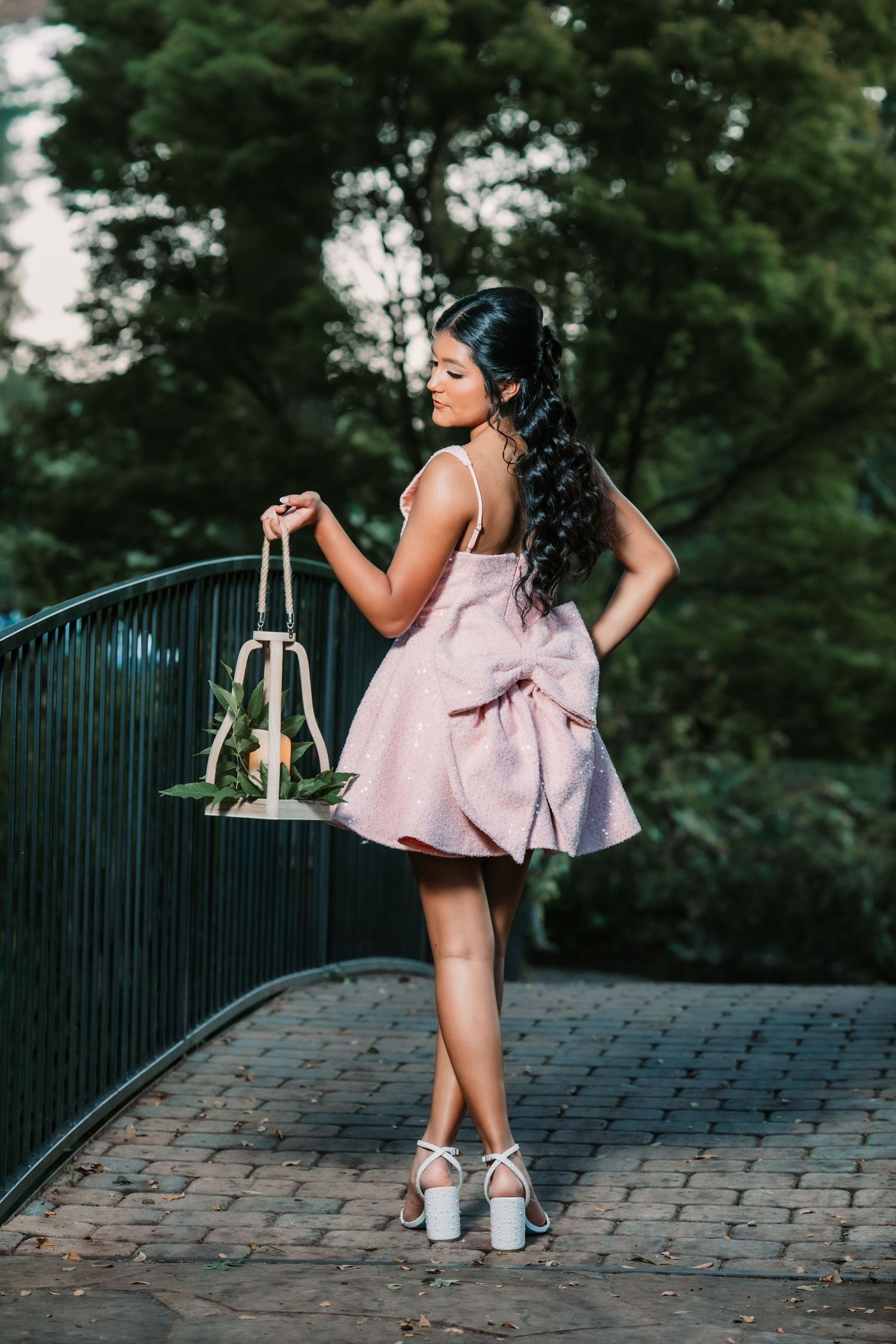 A playful photoshoot on a stone pathway featuring a pink dress and casual sneakers.