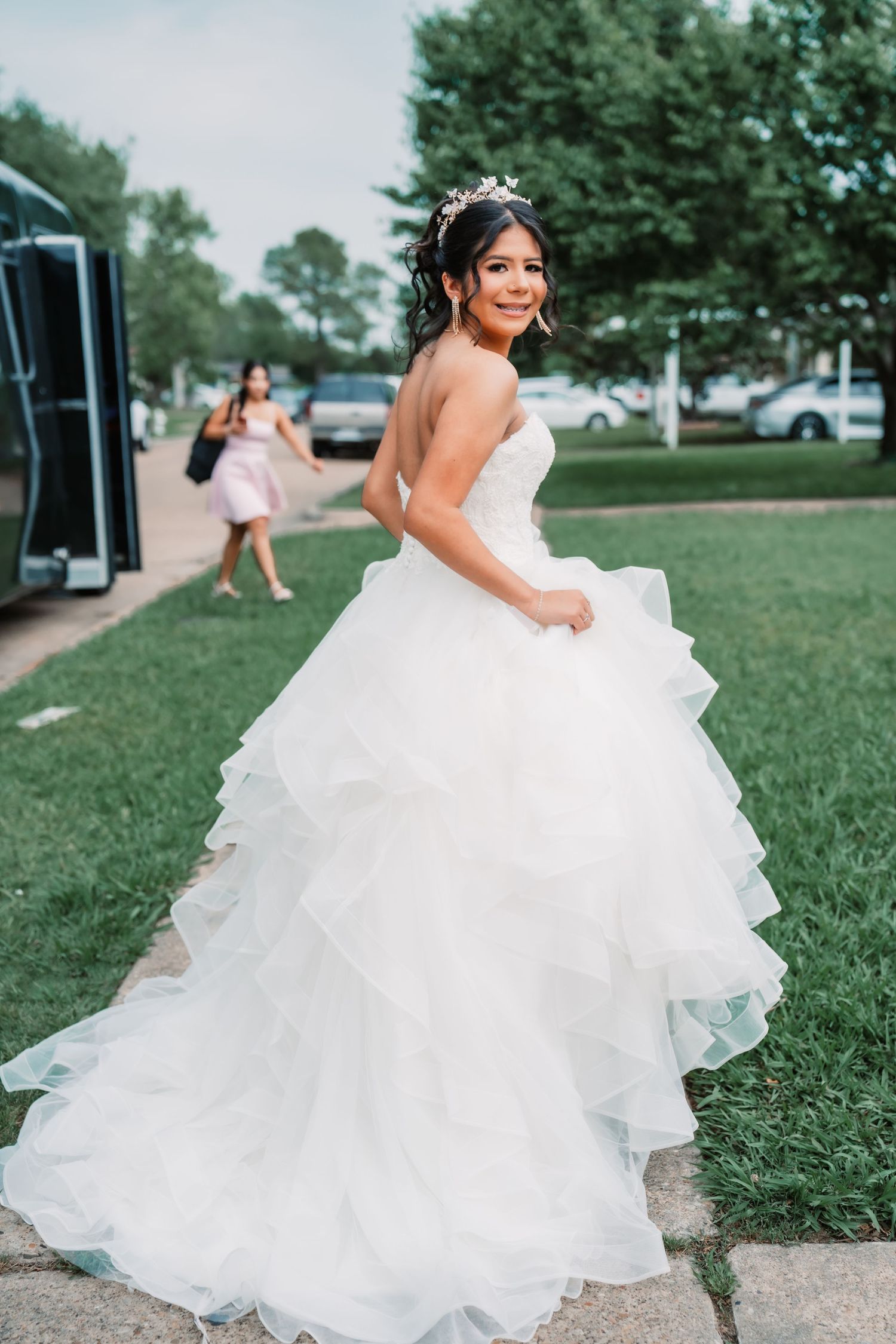 Flowing white wedding dress captured in motion across green grass.