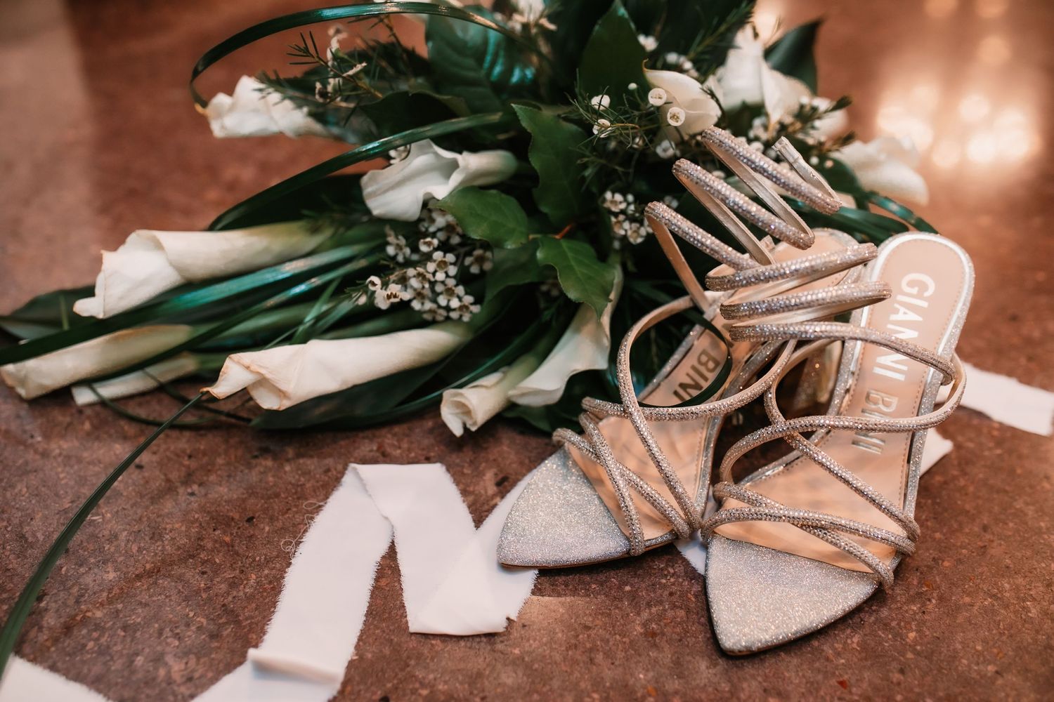 Elegant bridal shoes and accessories arranged in a styled wedding detail shot.