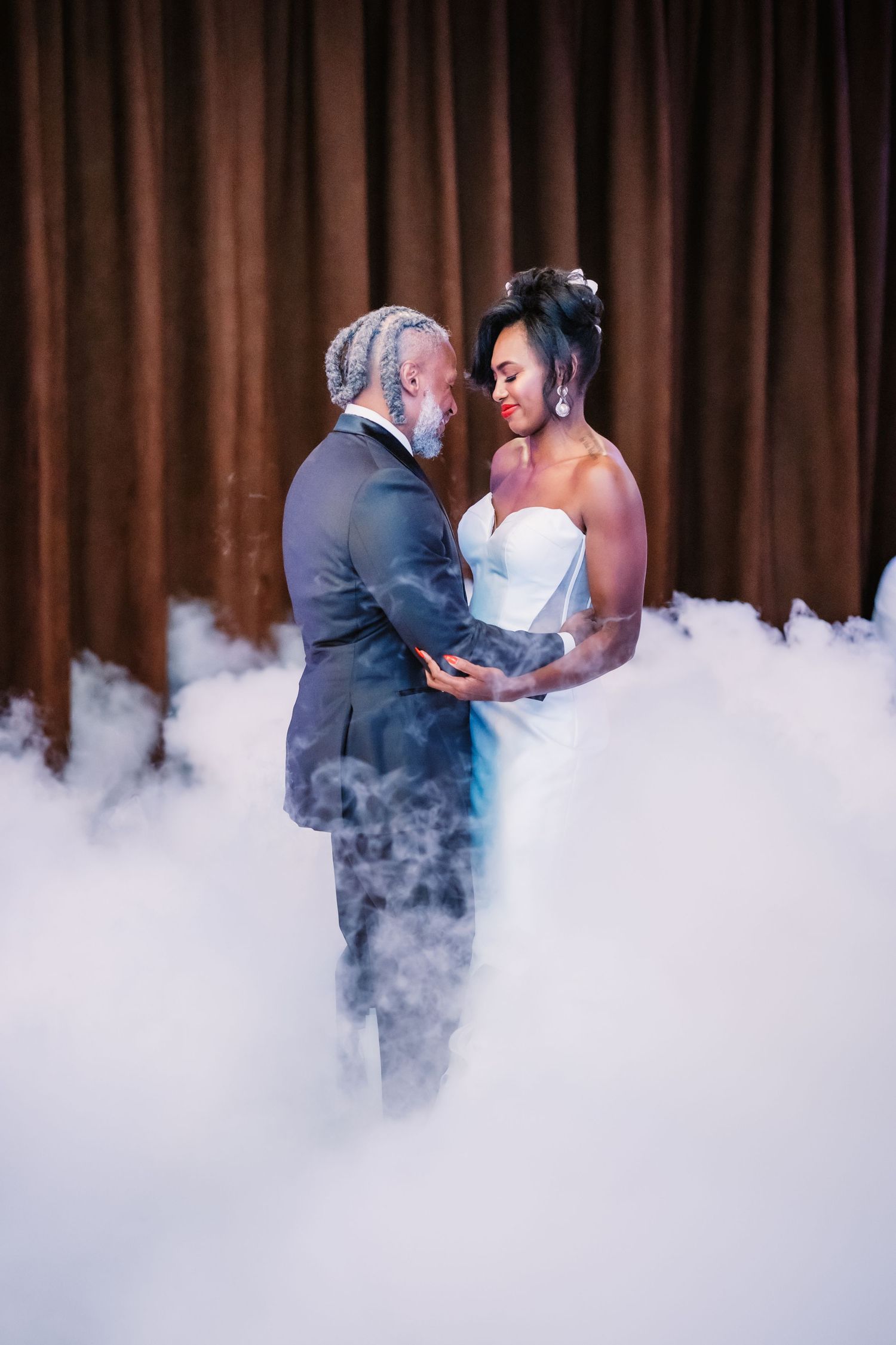 Romantic first dance with fog machine effects creating dreamy atmosphere.