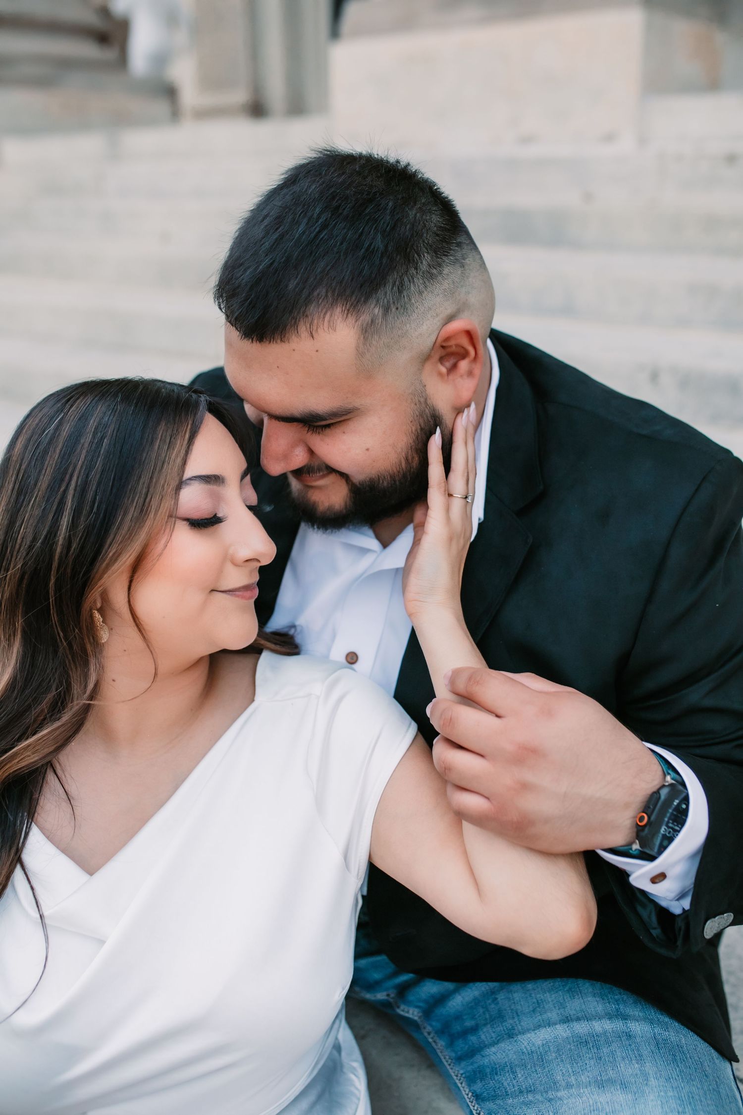 Intimate engagement photos showing tender moments between a couple on stone steps.