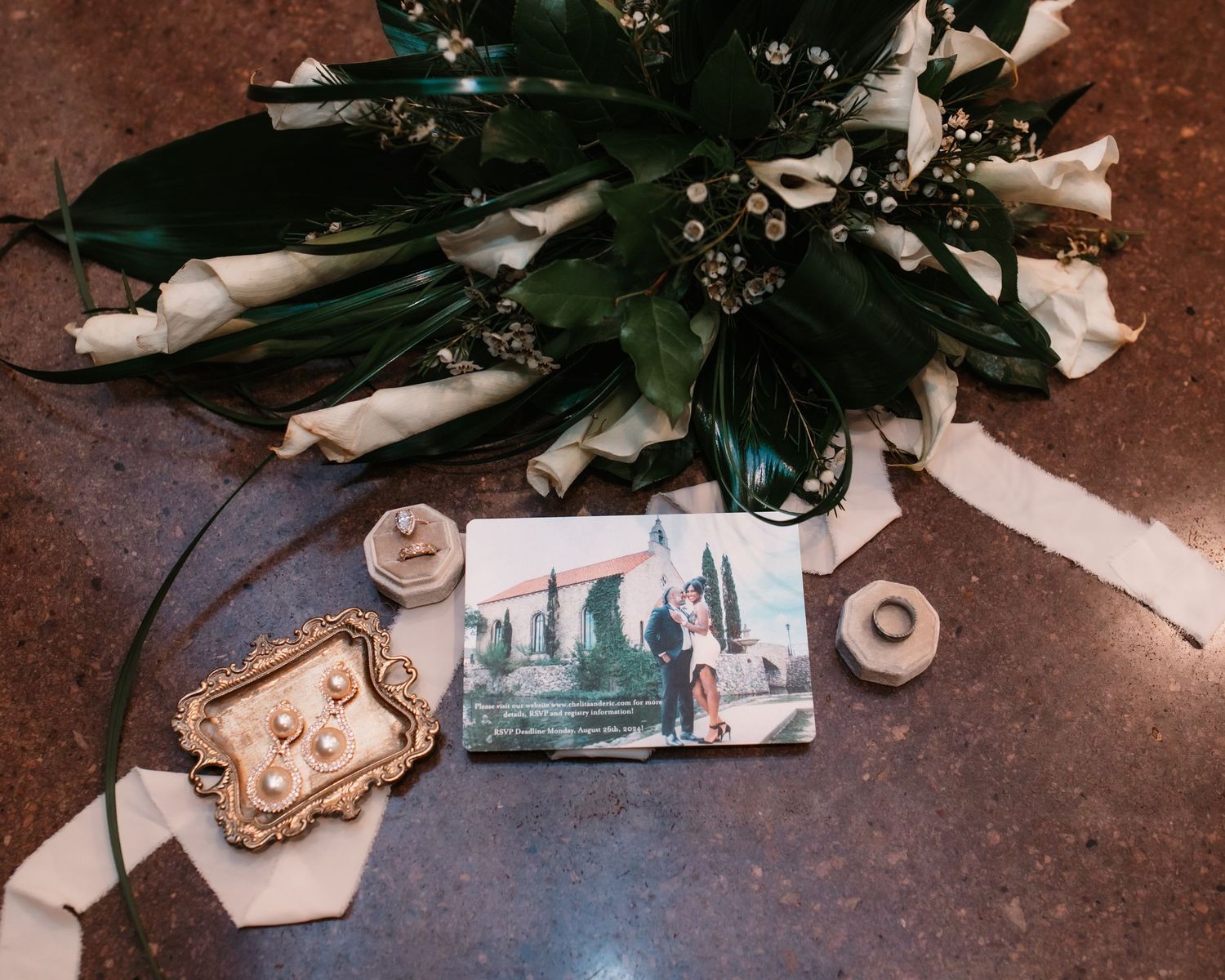Wedding accessories and details arranged artistically including jewelry and paper items.
