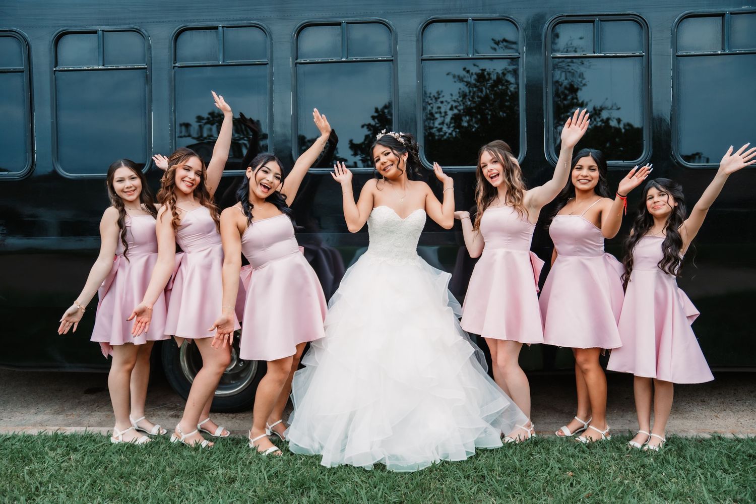 Fun and energetic quinceanera photo with her damas in pink dresses.