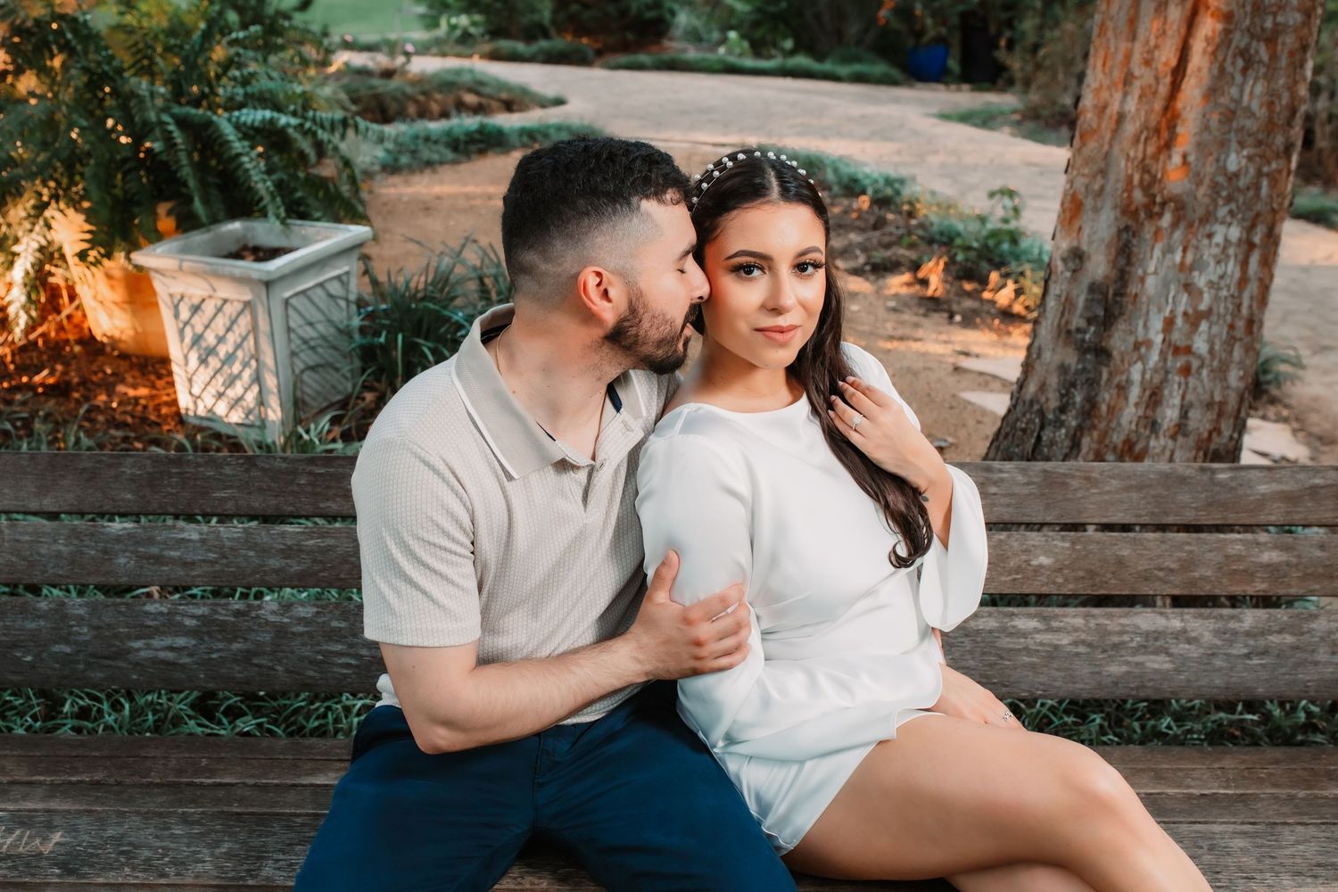 Sunset engagement session with couple sharing intimate moments in park.