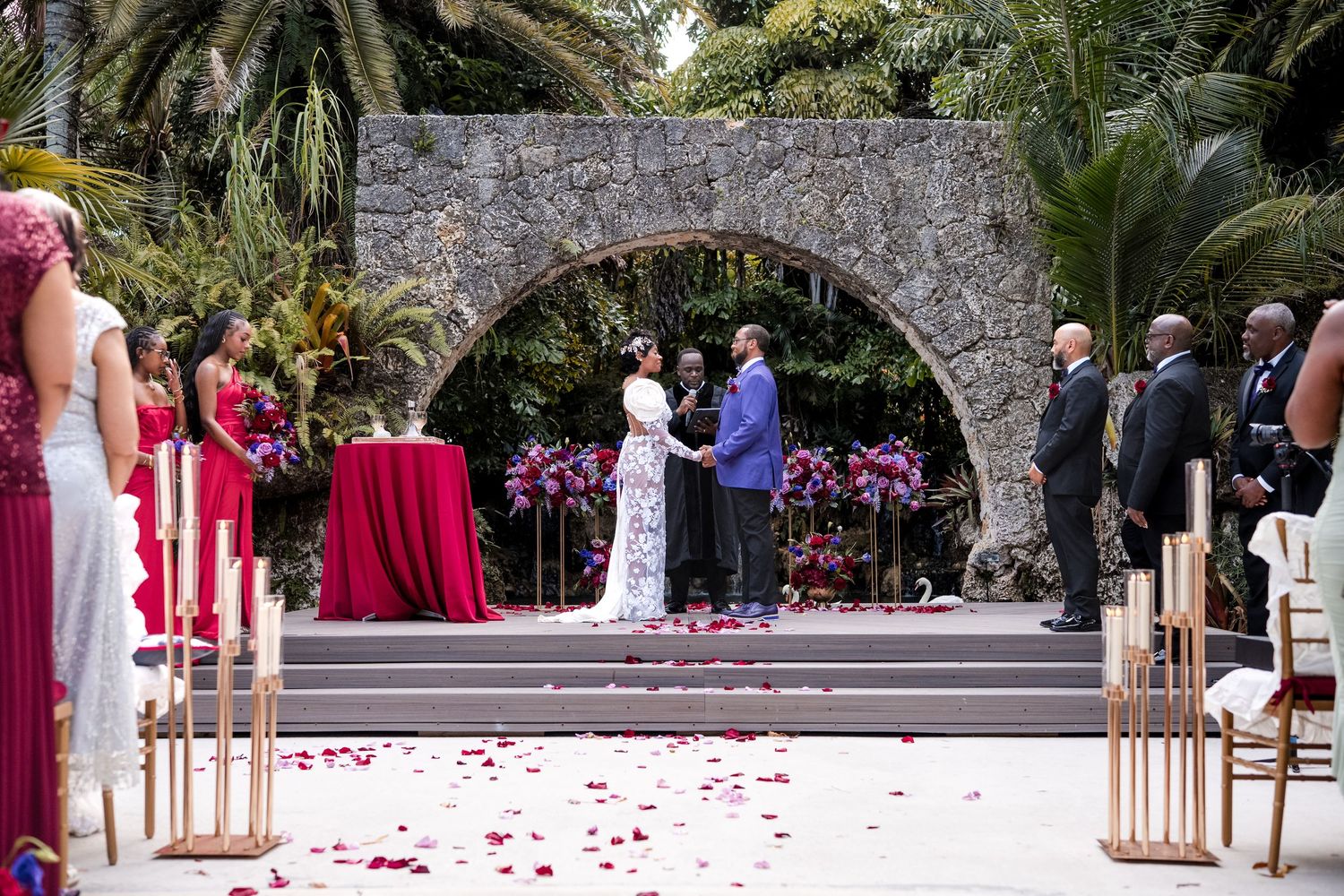 Outdoor wedding ceremony beneath a stone arch at Secret Gardens Miami
