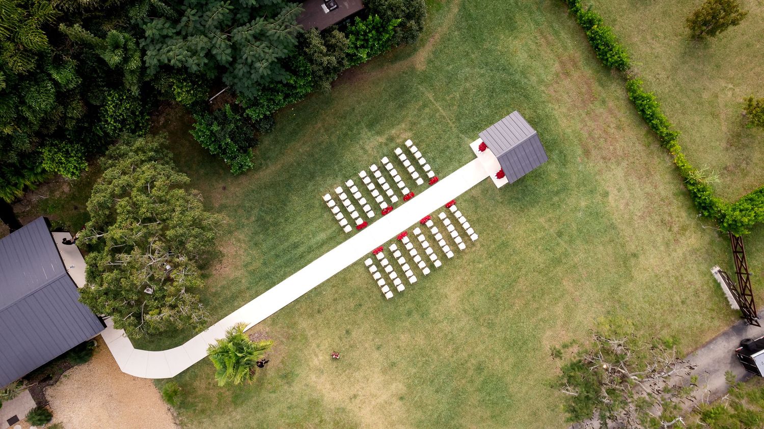 Aerial view of an outdoor wedding ceremony setup surrounded by greenery