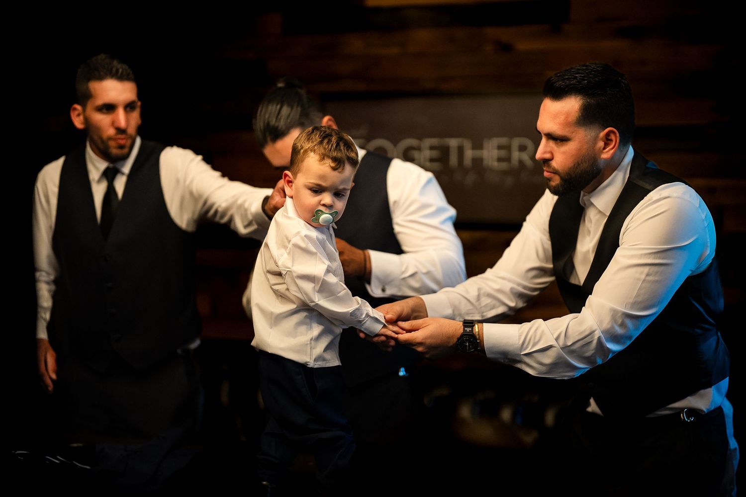 Groomsmen sharing a candid moment with a child before the wedding