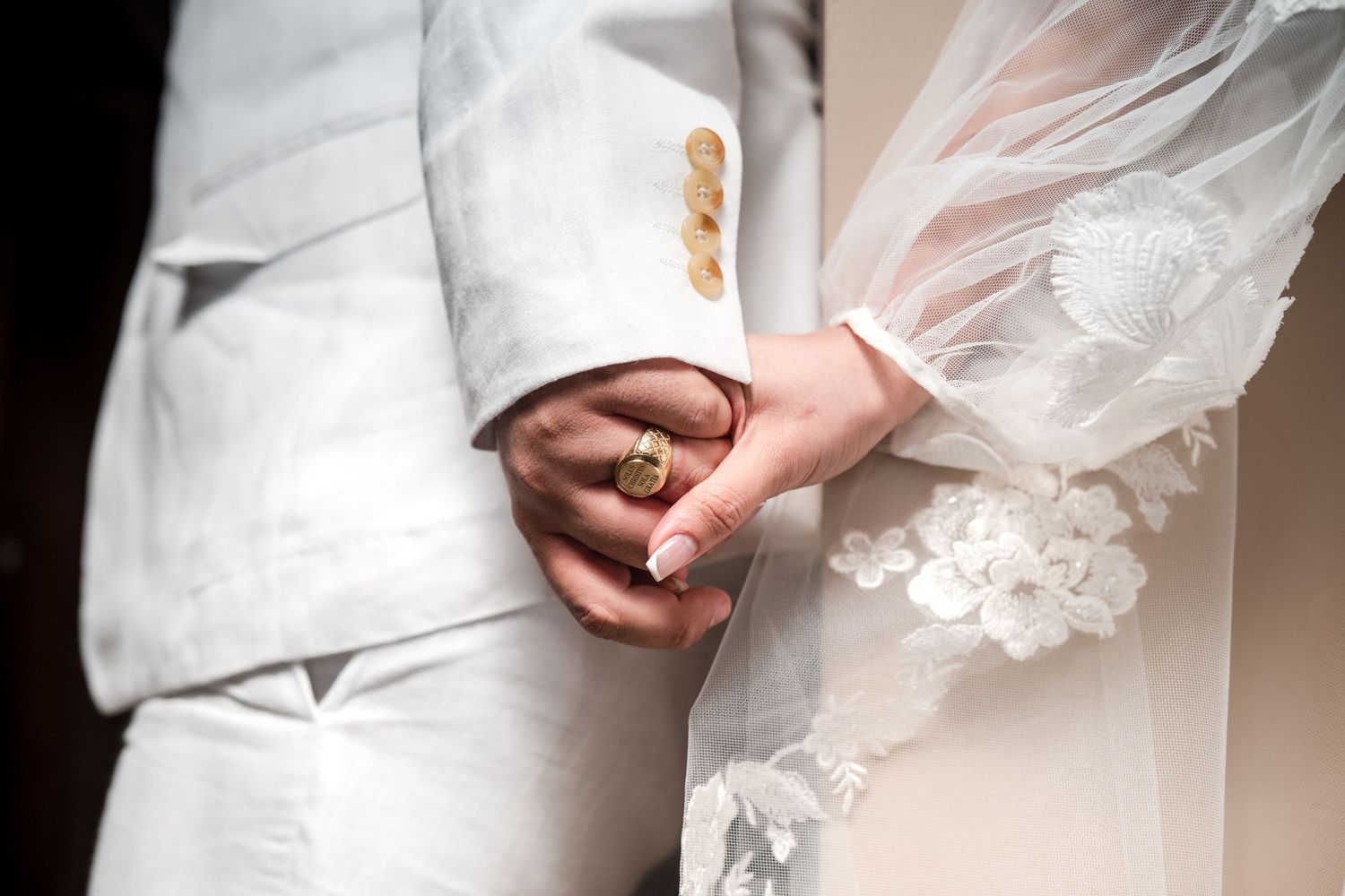 Close-up of newlyweds holding hands during their wedding day