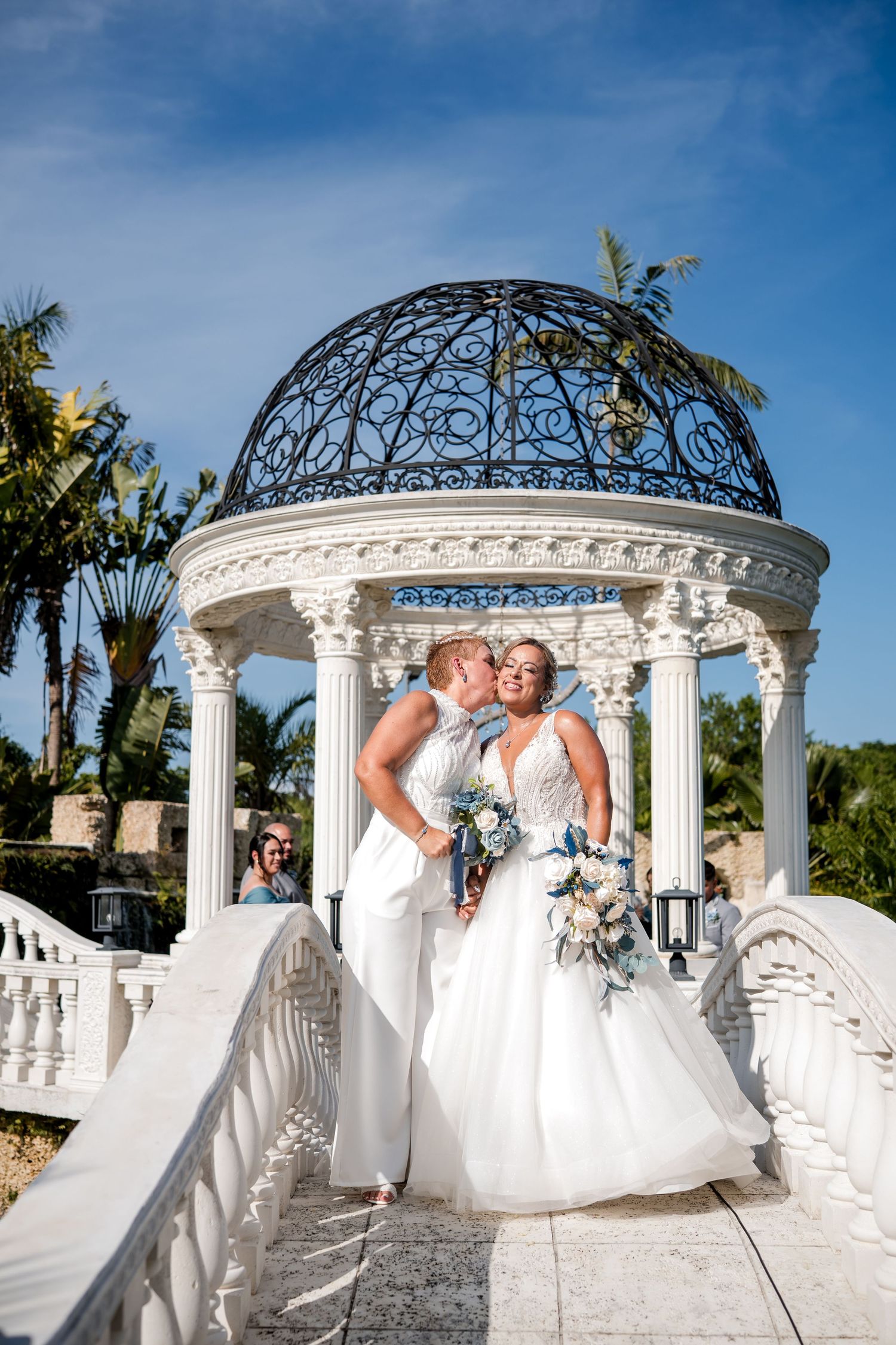 Bride and groom posing beneath a garden gazebo during their wedding at Little Paradise Farm