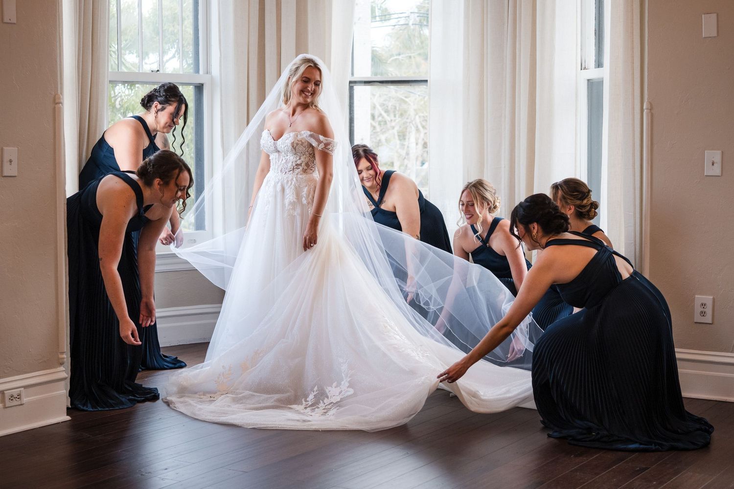 Bridesmaids helping the bride with her wedding dress before the ceremony