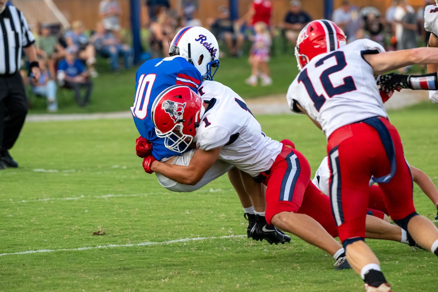 Football players tackling during a competitive high school game.