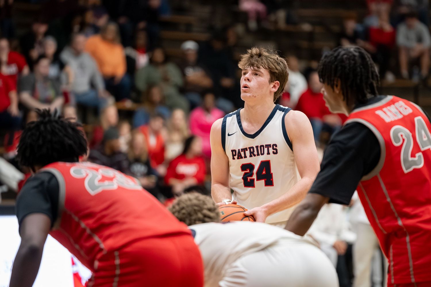 Heritage Hills Patriots basketball player number 24 prepares for a free throw surrounded by opponents.