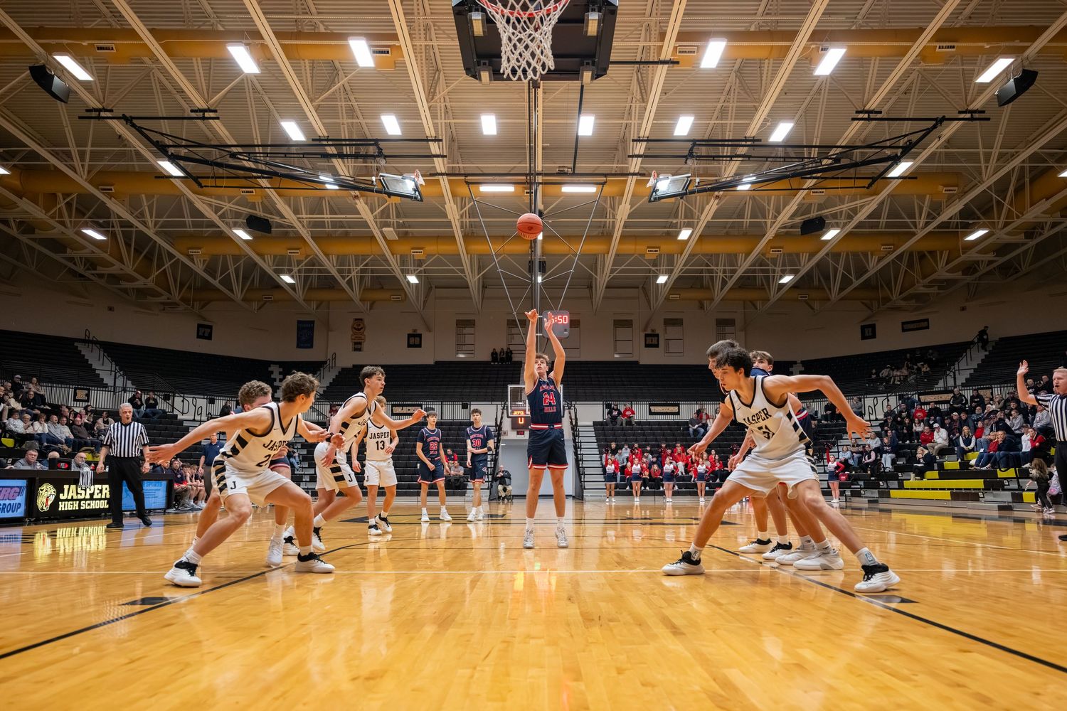 Heritage Hills Patriots Basketball player shoots a free throw in a large arena during a competitive game.