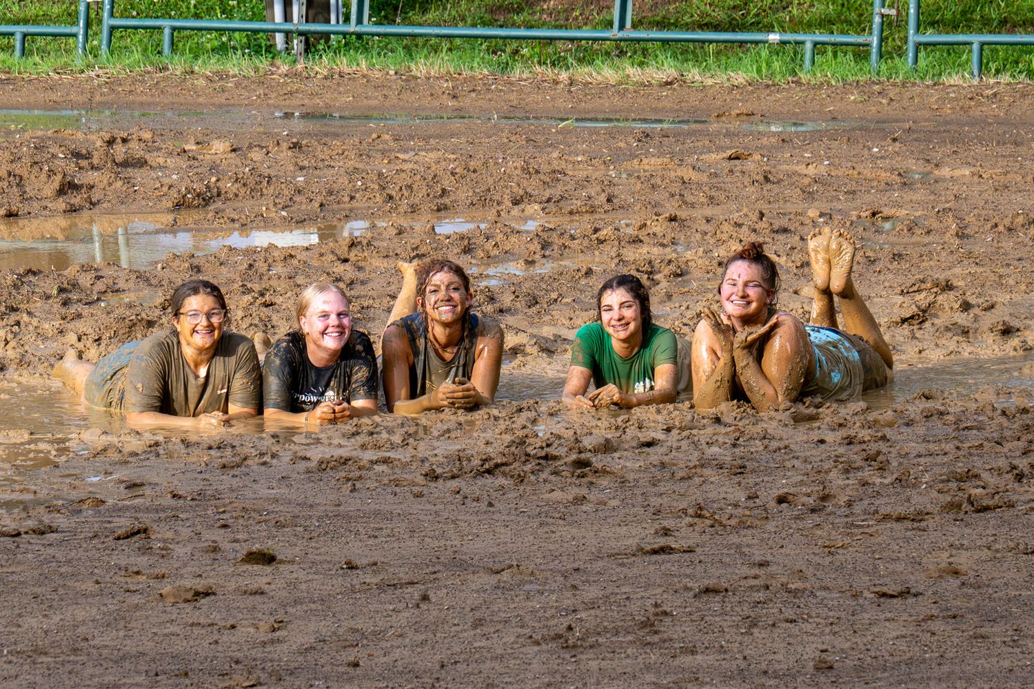 Five smiling young women lying in mud during 2026 Spencer County 4H Fair.