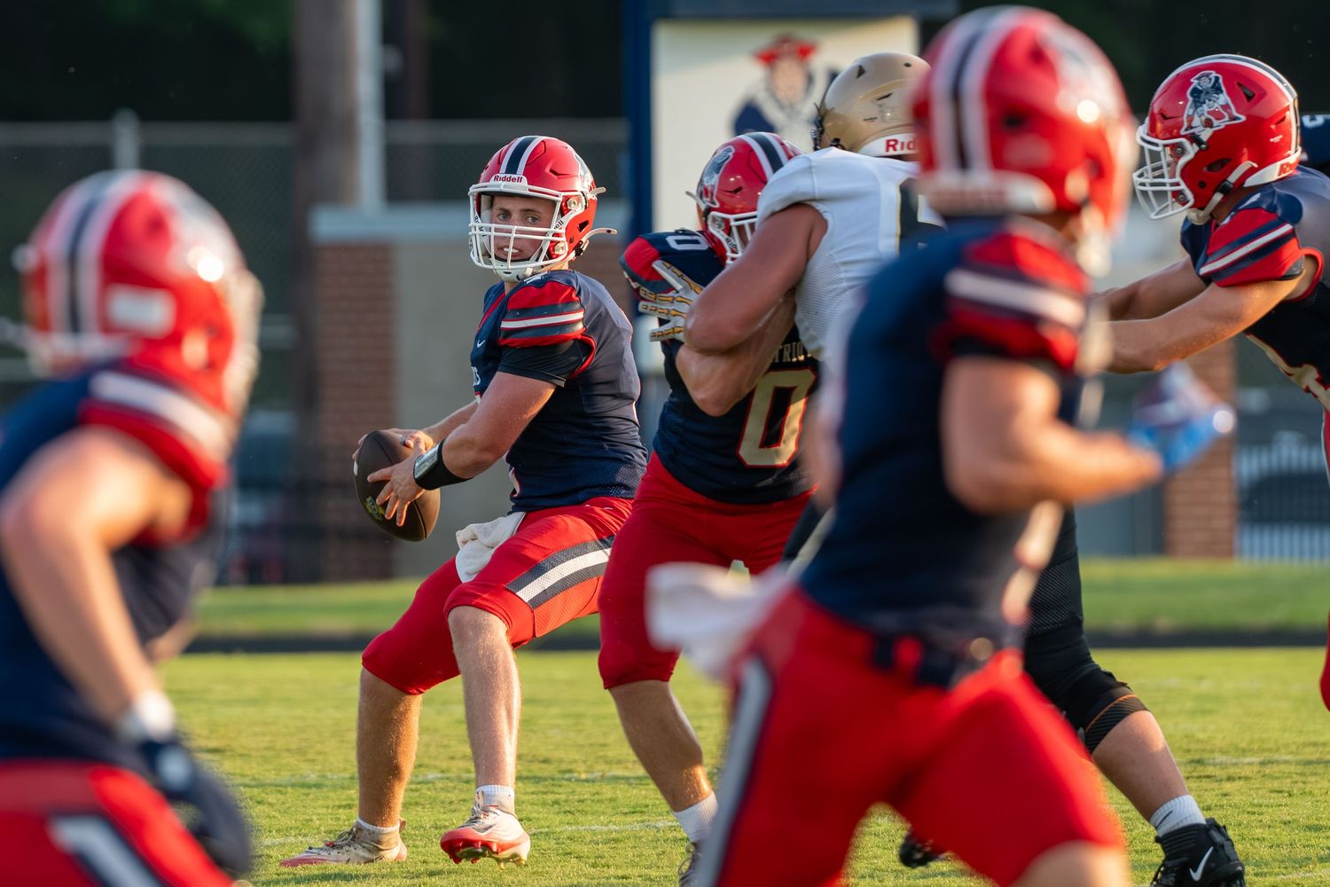 Quarterback preparing to throw during a high school football game.