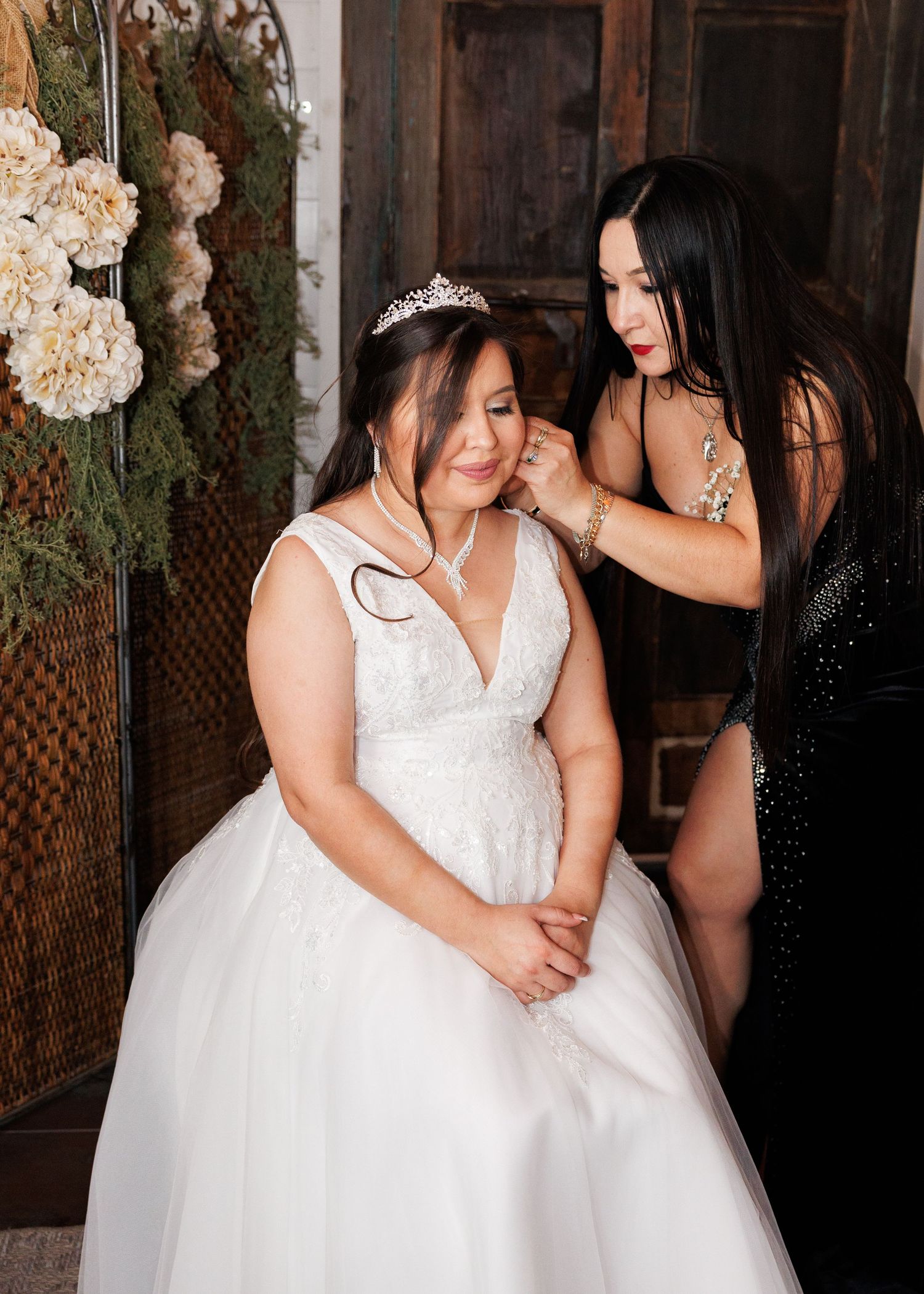 A touching pre-wedding moment in a rustic setting with soft lighting and floral decorations.