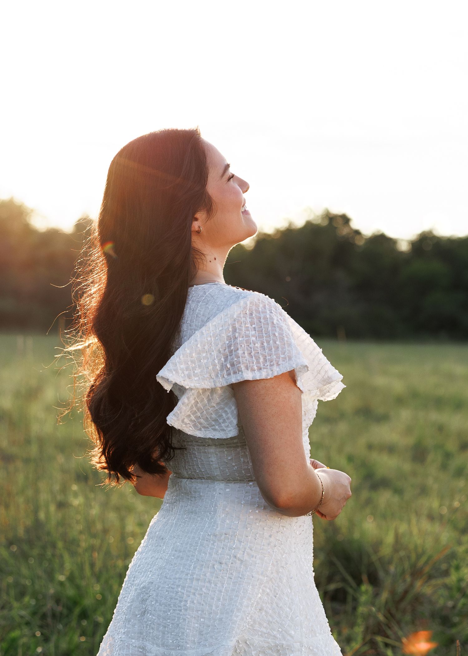 A series of outdoor portraits at sunset showing a person in a white eyelet dress against a golden field.