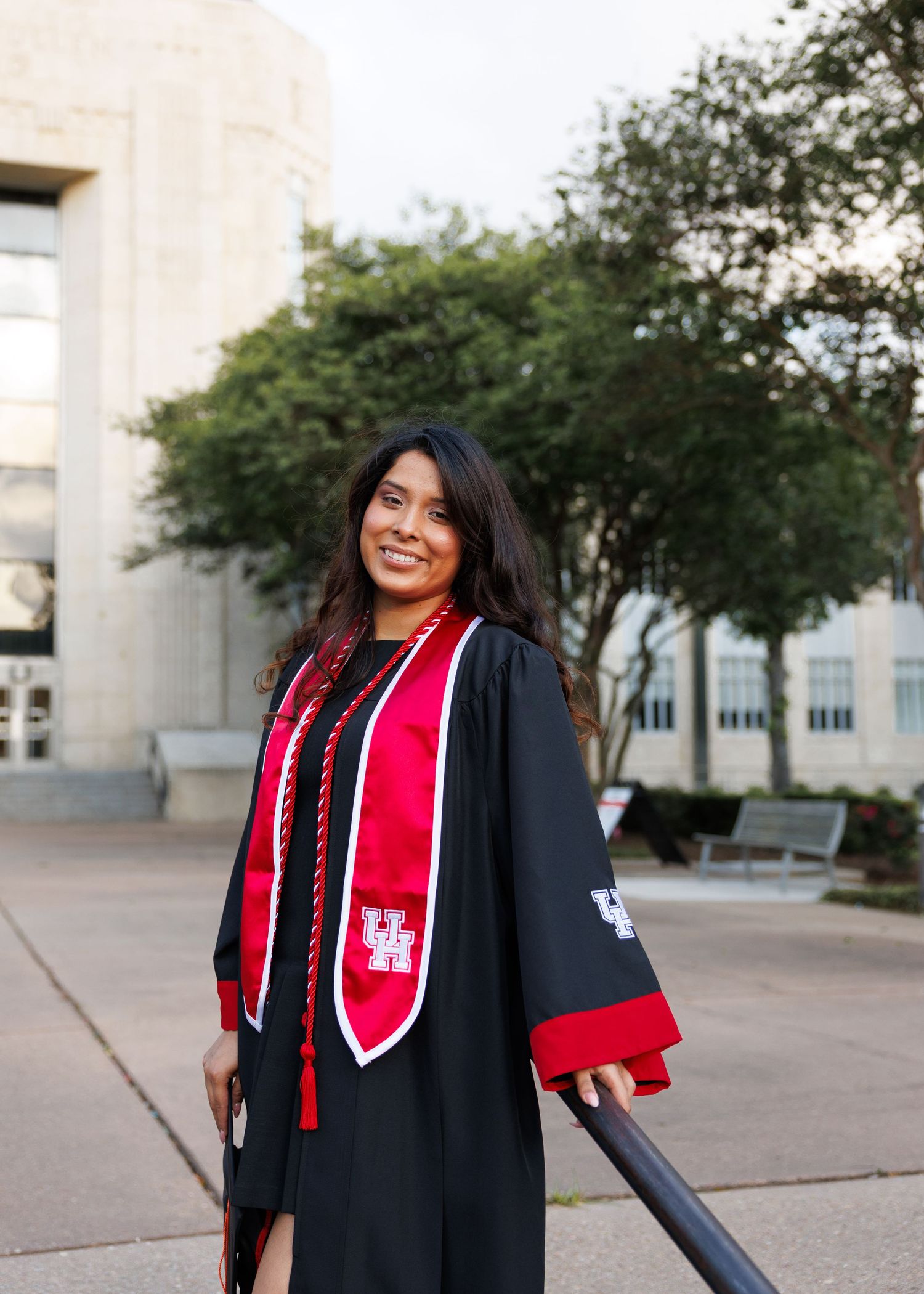 Four photos showing graduate in black cap and gown with red stole at University of Houston campus.