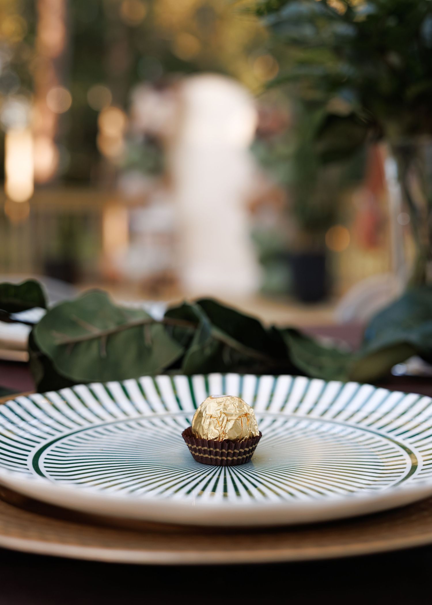 Close-up of striped decorative plates with desserts arranged on wooden surface with blurred natural background.