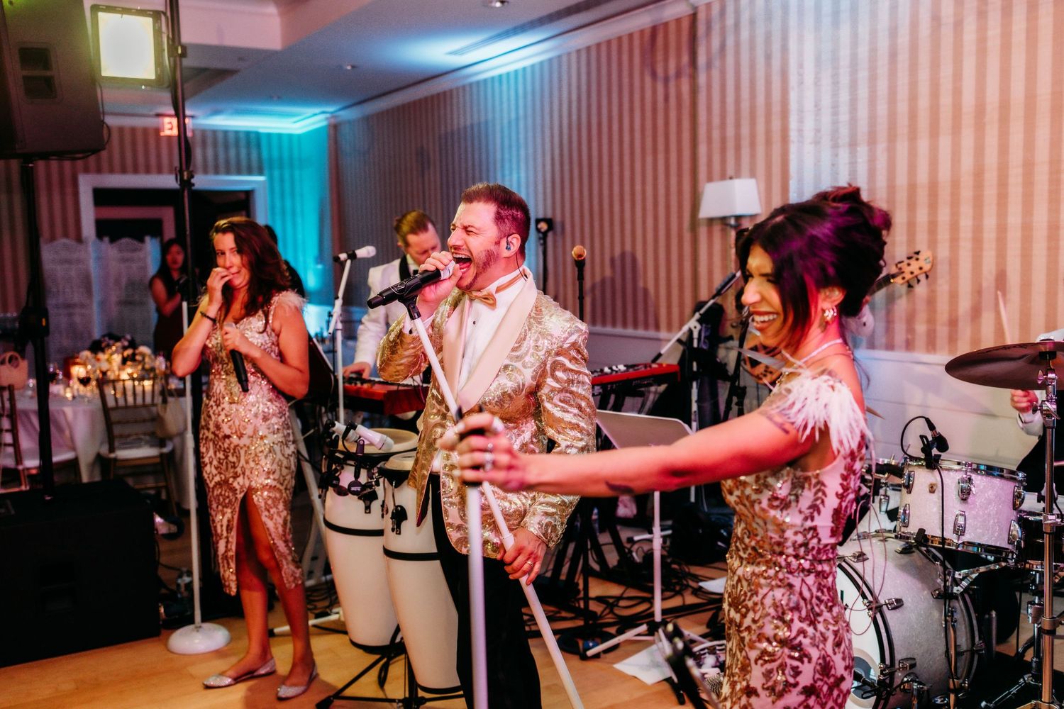 Wedding reception dance party with colorful lighting and guests dancing on the dance floor.
