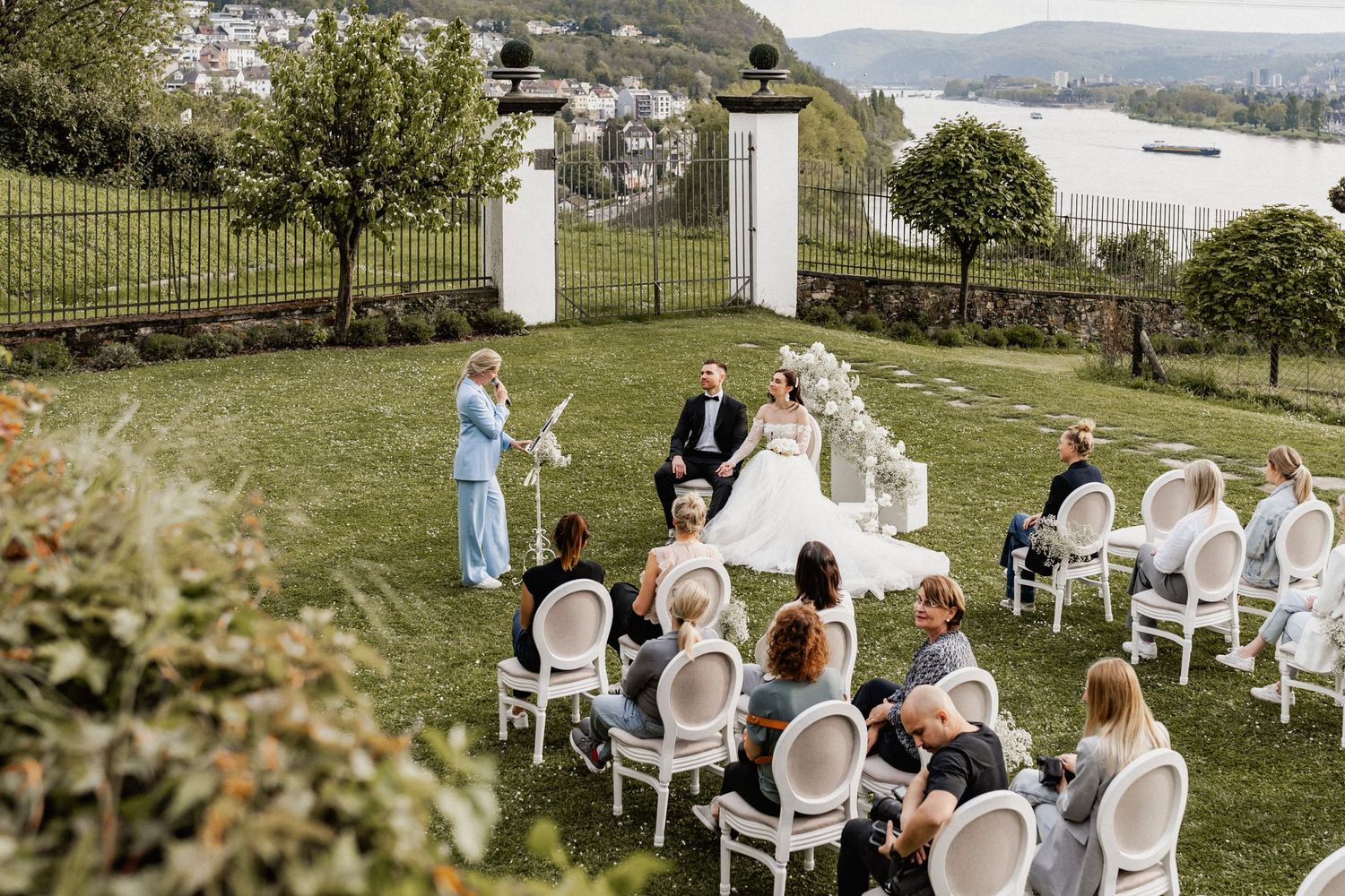 An intimate outdoor wedding ceremony setup with white chairs and mountain views.